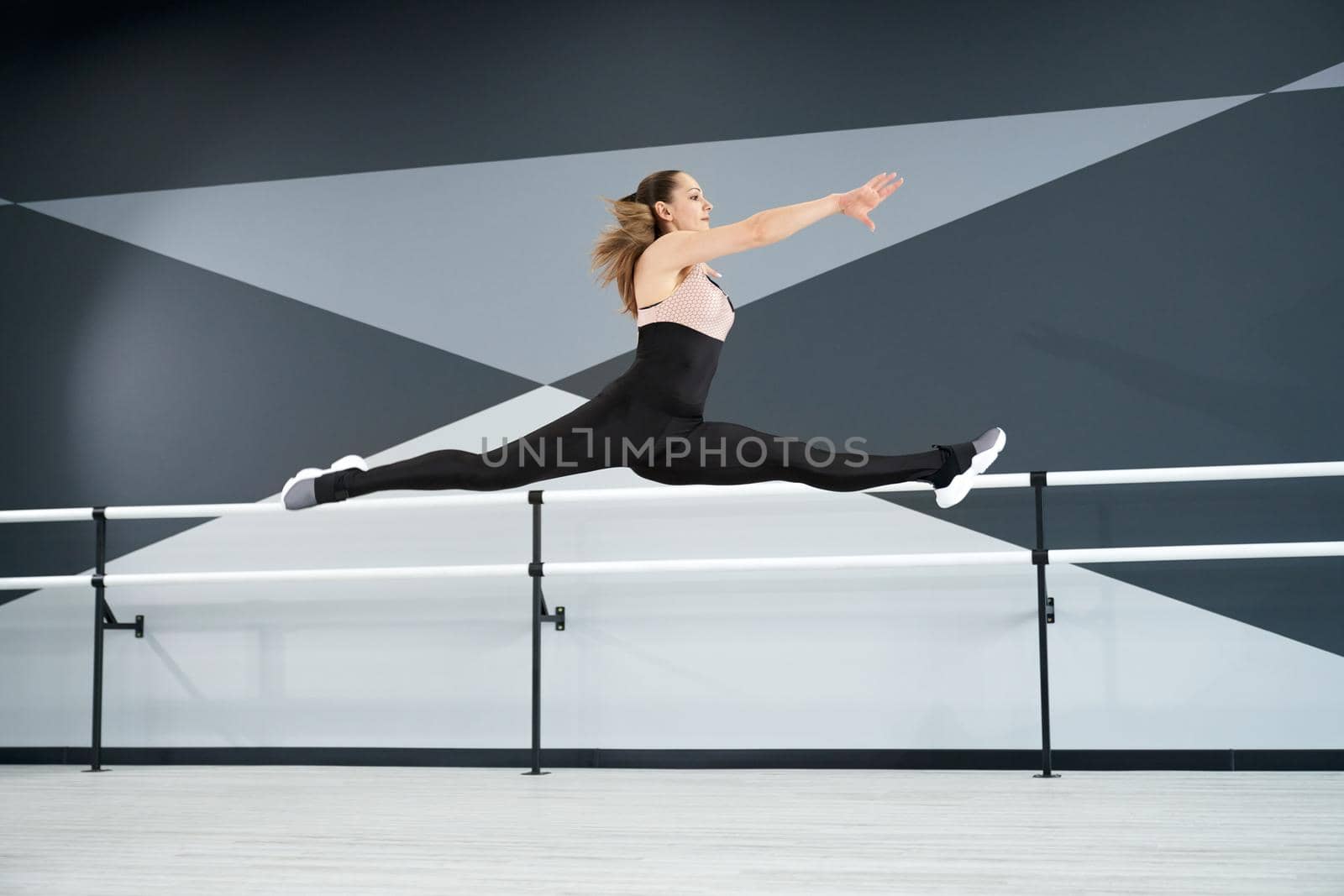 Female teenager jumping, practicing splits in air. by SerhiiBobyk