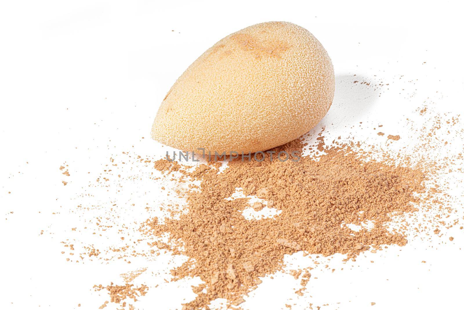 Cosmetic sponge with powder isolated on a white background. Loose makeup base.