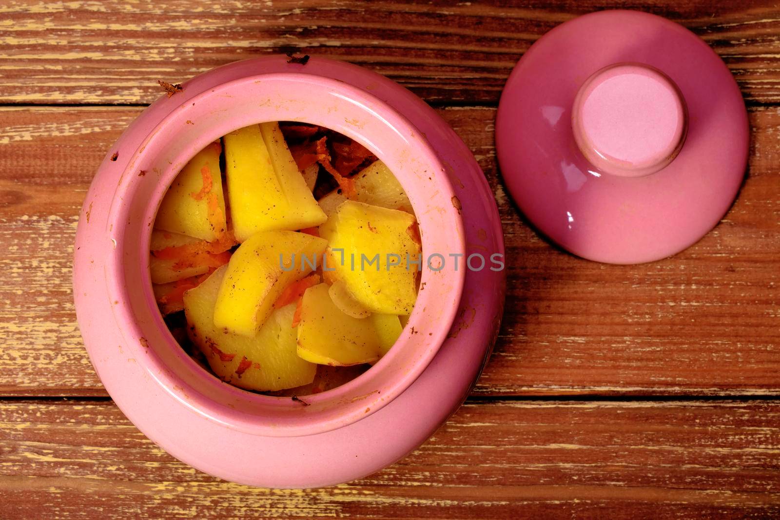 Pink pot with stew potatoes top view.