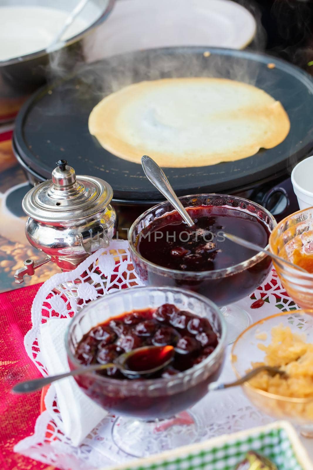 Maslenitsa holiday.Jam in a vase and a delicious pancake in a pan.