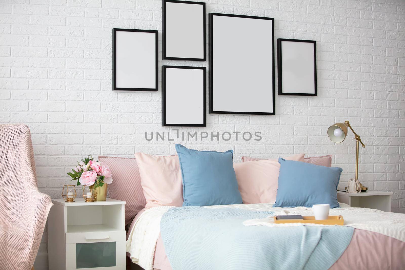 Part of the bedroom with bed and paintings.