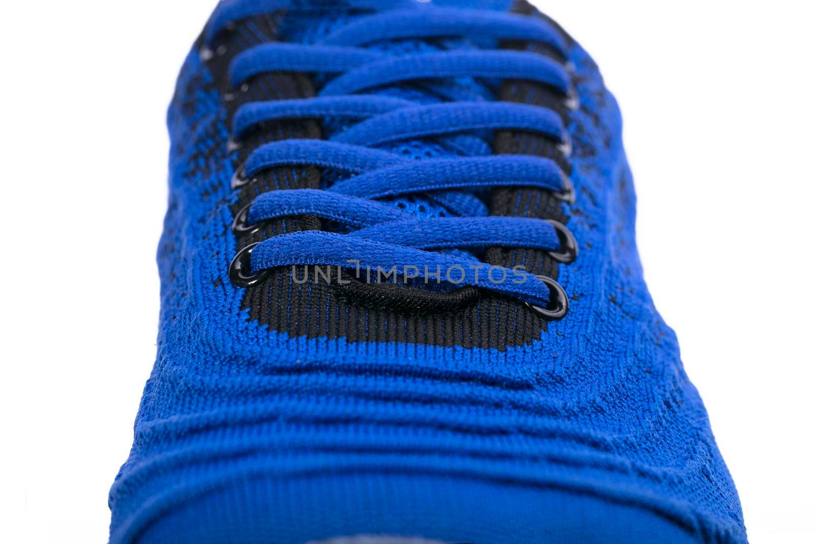 Part of a blue sneaker made of fabric with laces. A fragment of sports shoes.