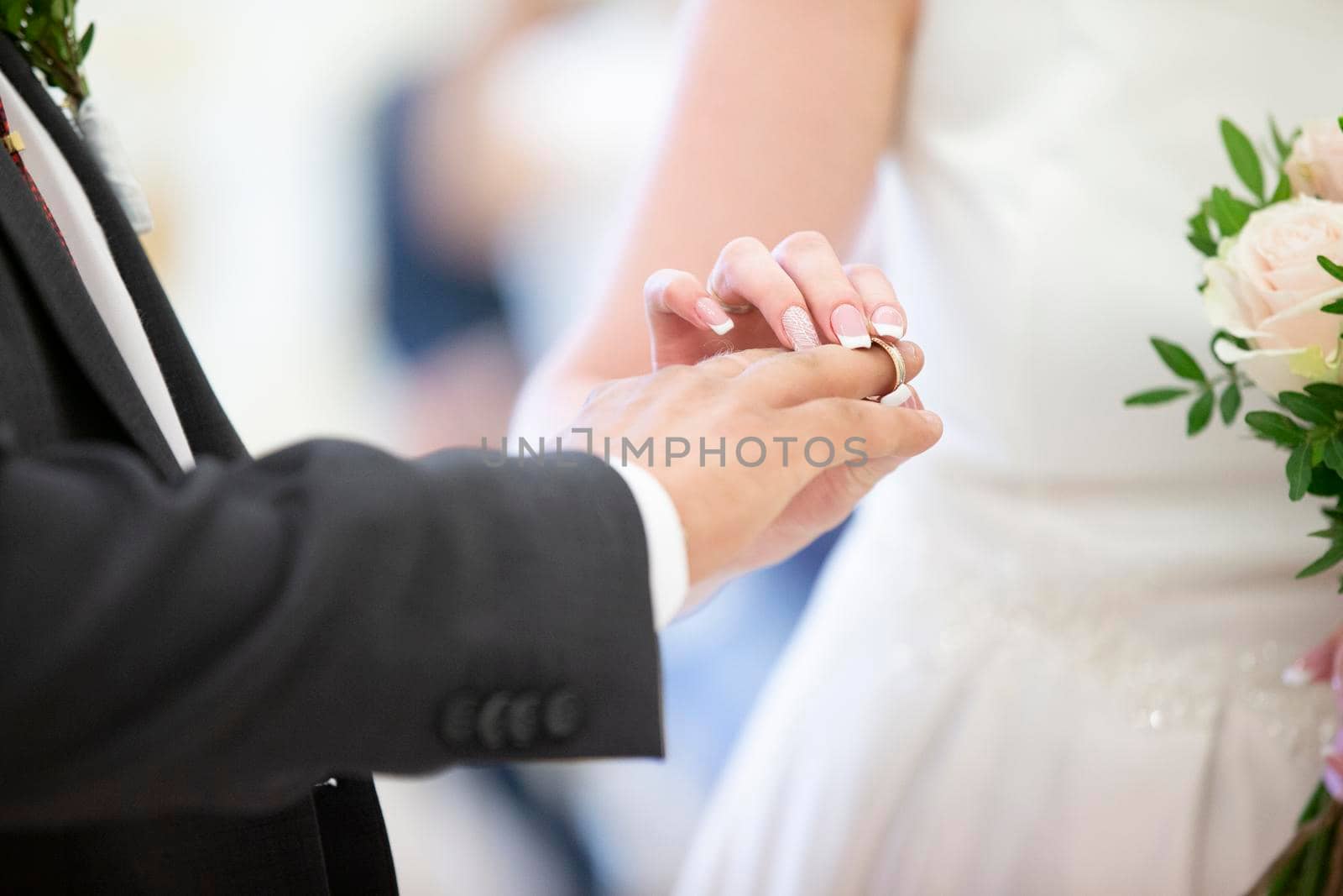 Wedding day. The bride dresses the ring to the groom. Hands of the newlyweds.