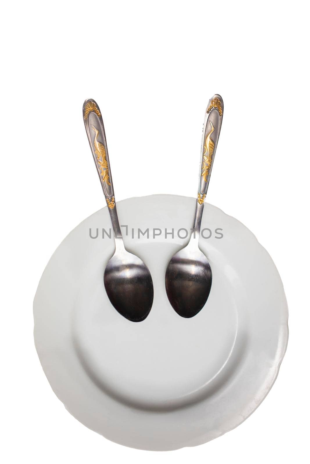 Plate with spoons on a white background. Funny dishes. Plate with a smile.
