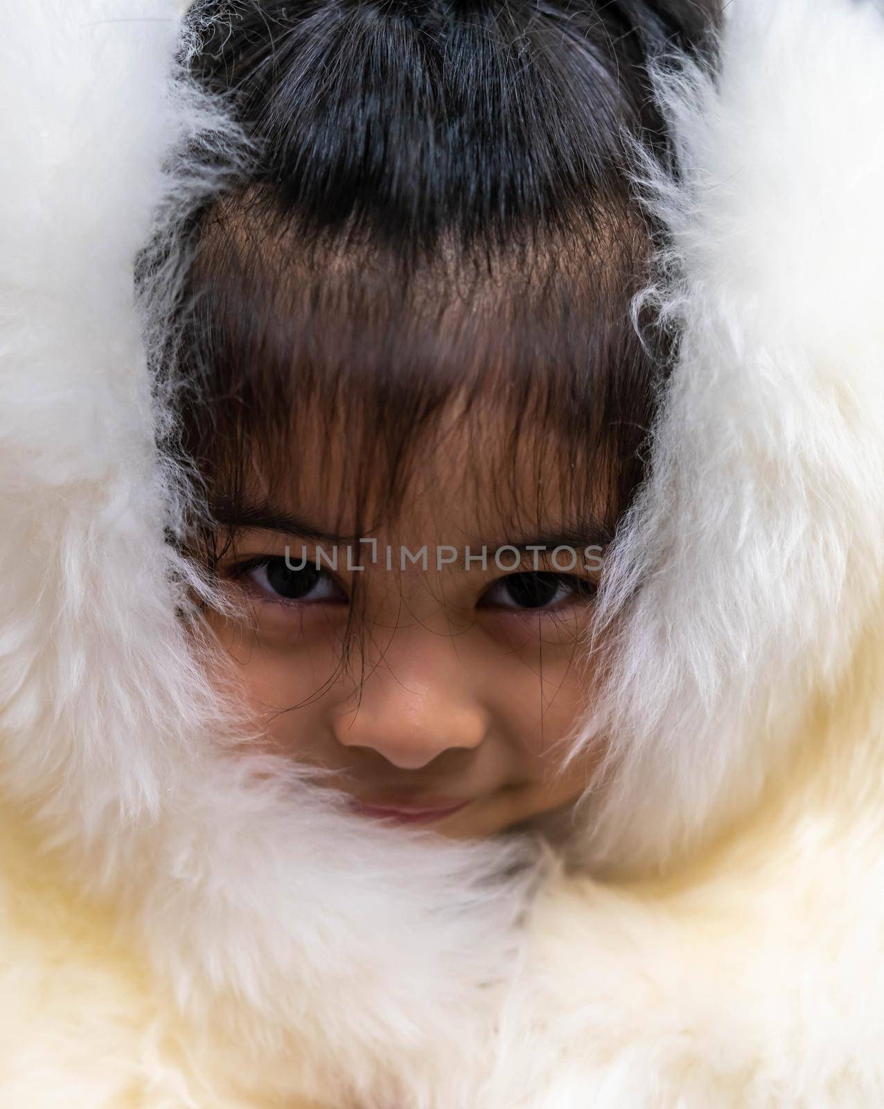 Pretty asian child wearing a white coat made of fur. Pretty asian model wearing white fur coat