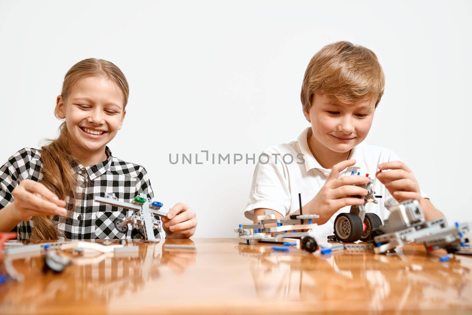 Young friends having fun, using building kit. by SerhiiBobyk