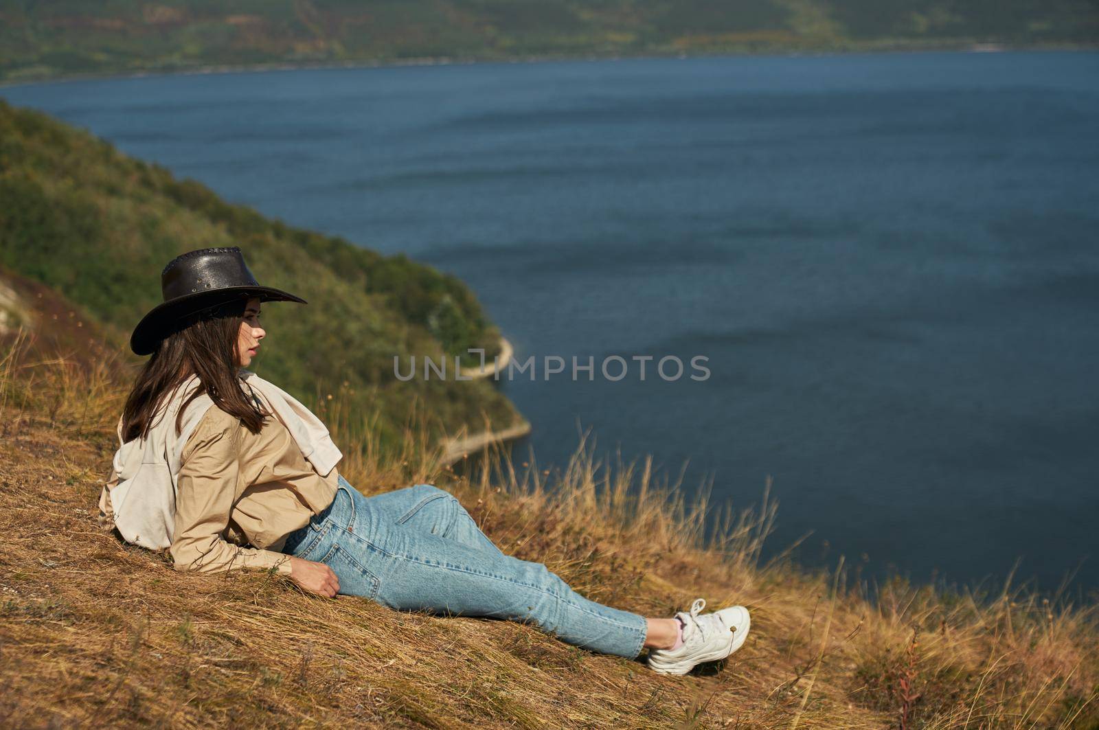 Woman lying on high hill and enjoying scenic landscape by SerhiiBobyk