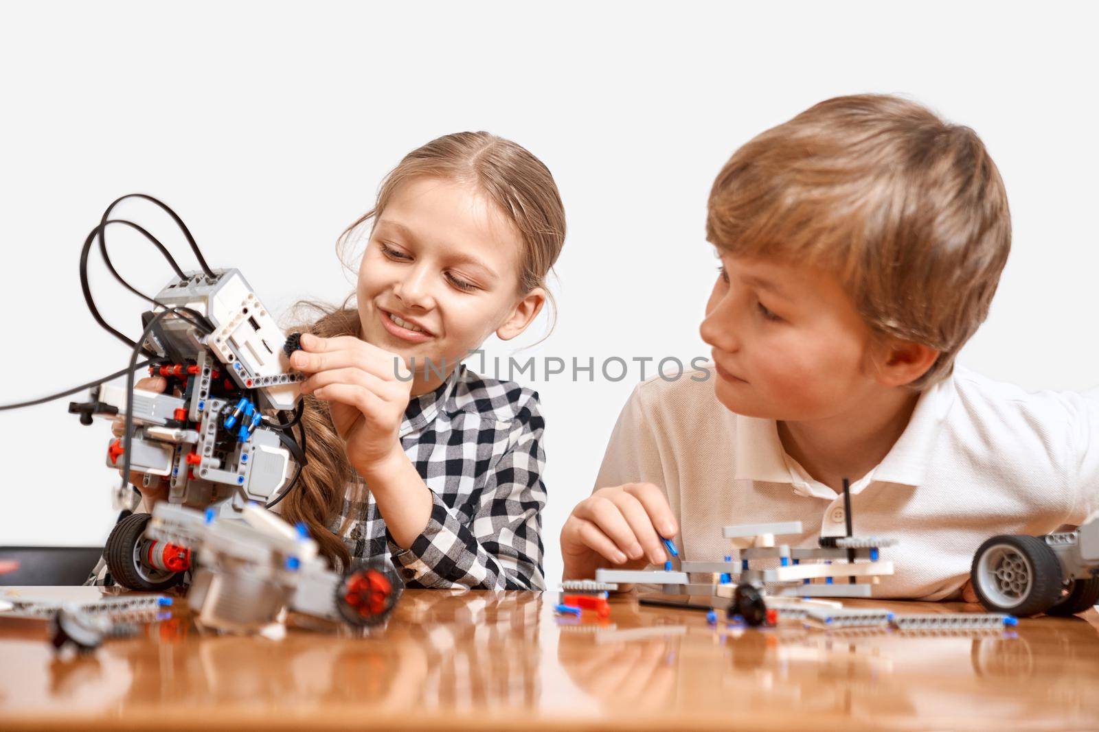 Young friends creating robot using building kit. by SerhiiBobyk