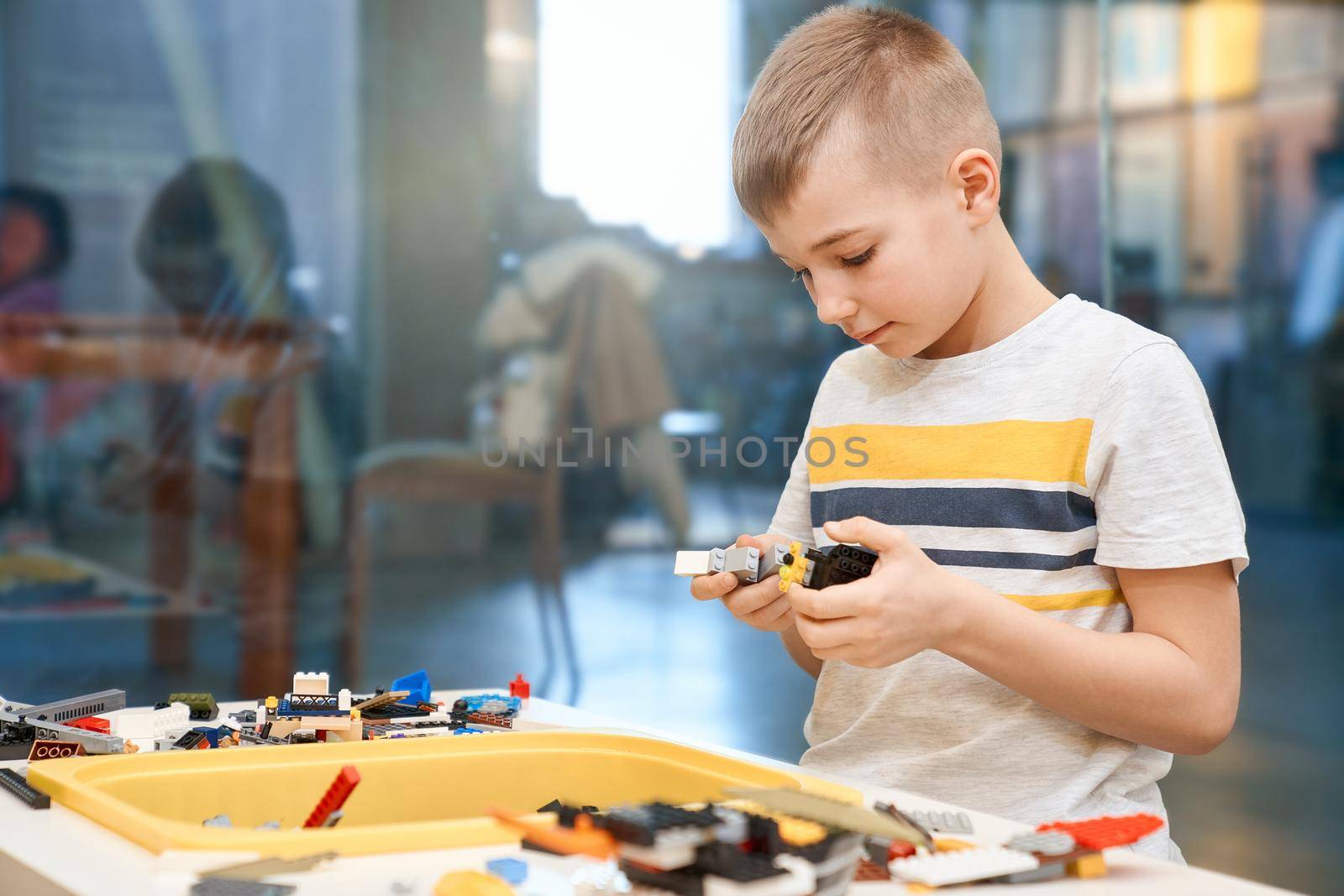 Caucasian boy using building kit. by SerhiiBobyk