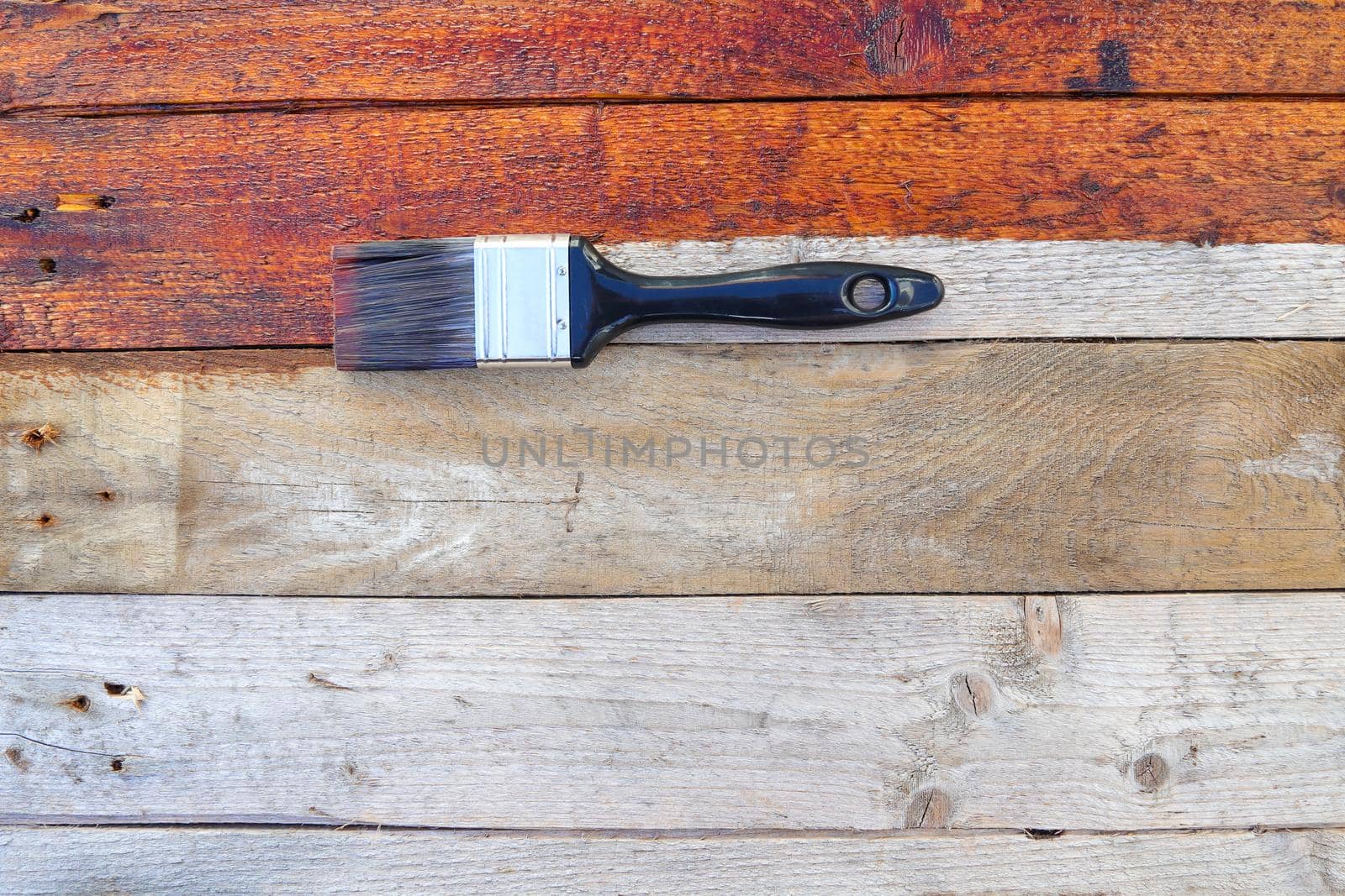 Rustic old wood surface sealant treatment with paintbrush flat-lay, South Africa