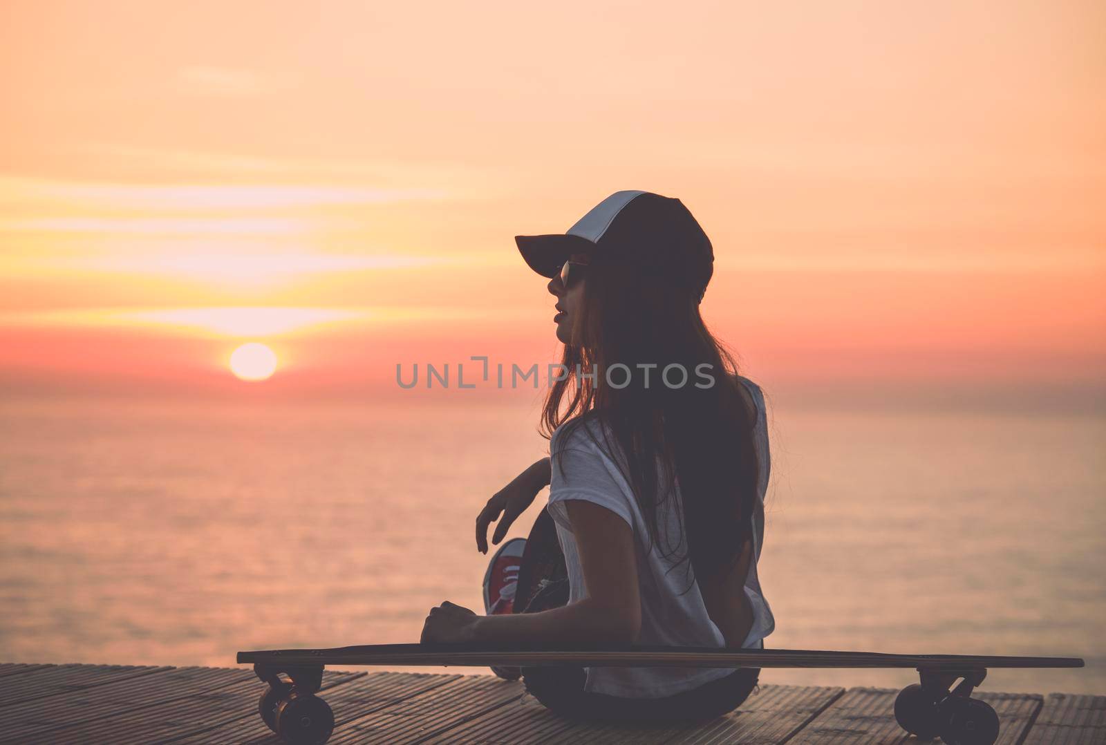 Beautiful fashion skater girl posing with  a skate board