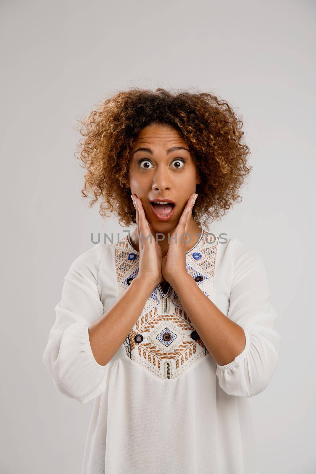 Beautiful African American woman smiling, isolated over a gray background