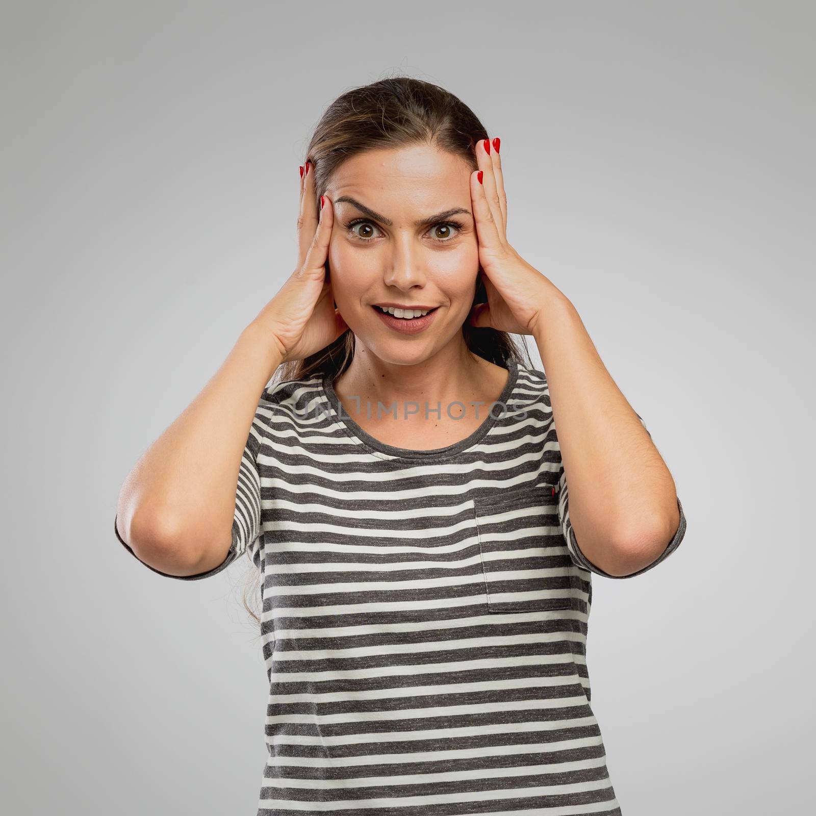 Portrait of a woman with a astonish expression, over a gray background