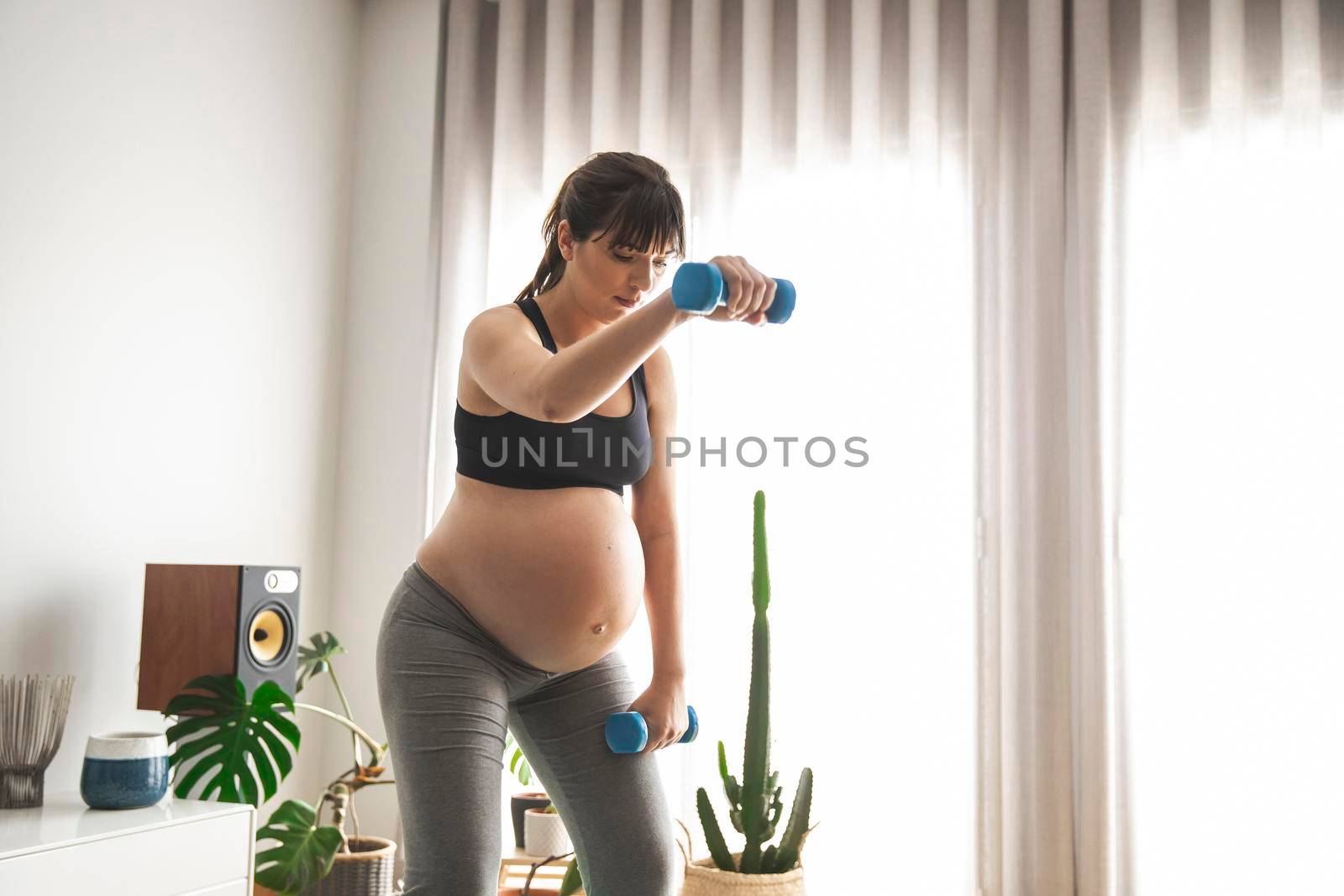 Pregnant woman doing exercises by Iko