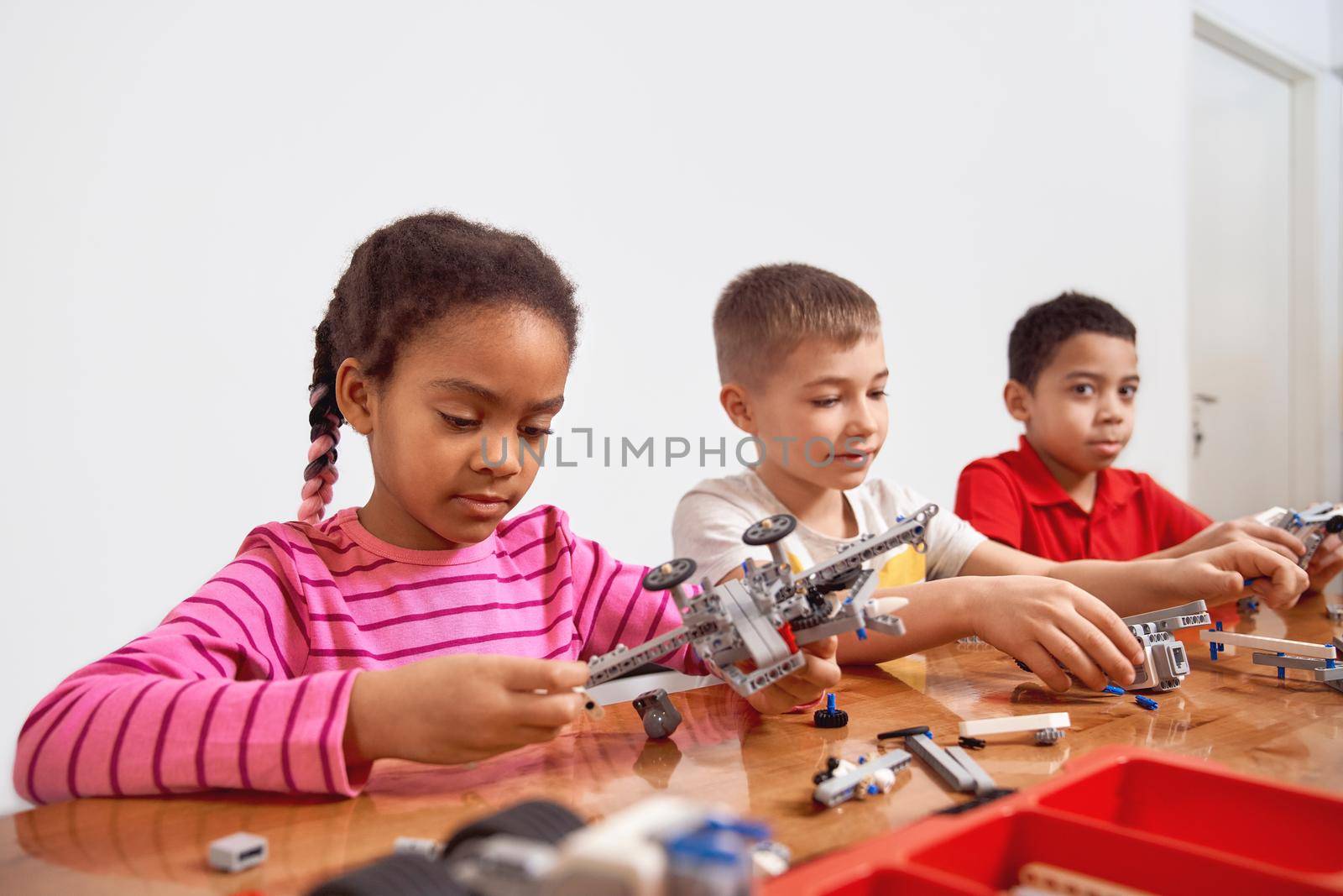 Kids using building kit to create toys. by SerhiiBobyk