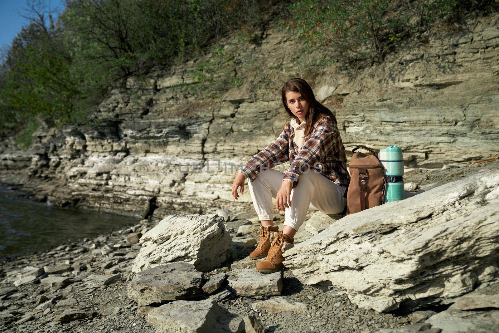 Pretty woman sitting on stone near Dniester river by SerhiiBobyk