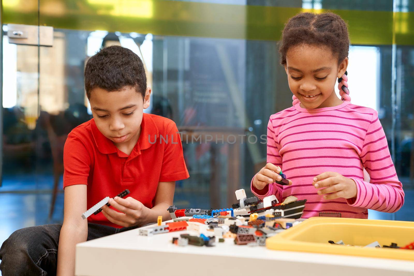 African girl and boy creating toys. by SerhiiBobyk