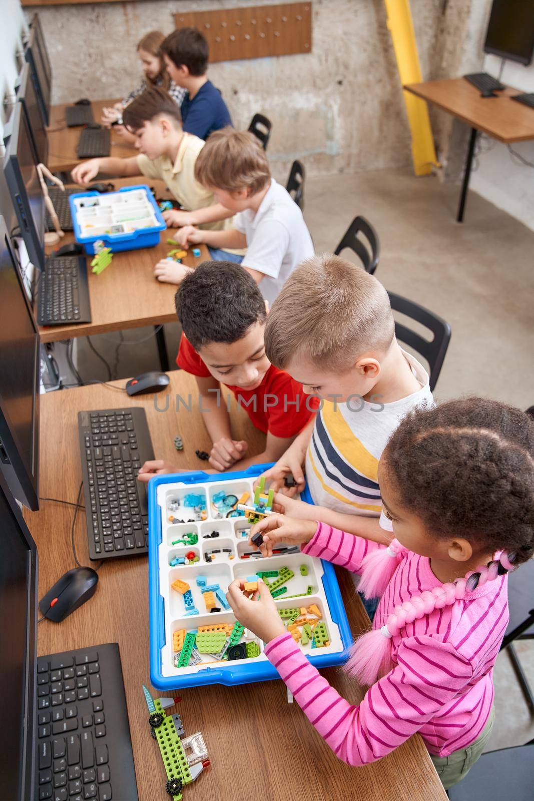 Young friends having fun, using building kit. by SerhiiBobyk