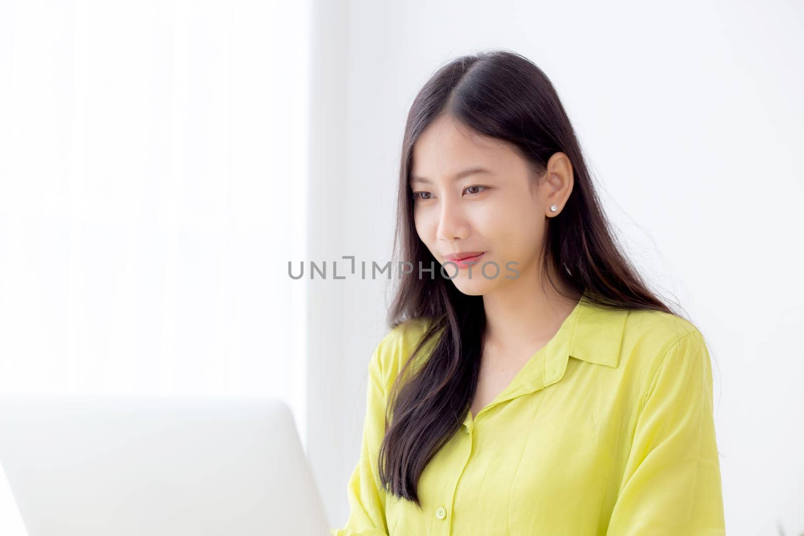 Young asian businesswoman working on laptop computer on desk at home office, freelance looking and typing on notebook on table, lifestyle of woman studying online, business and education concept.