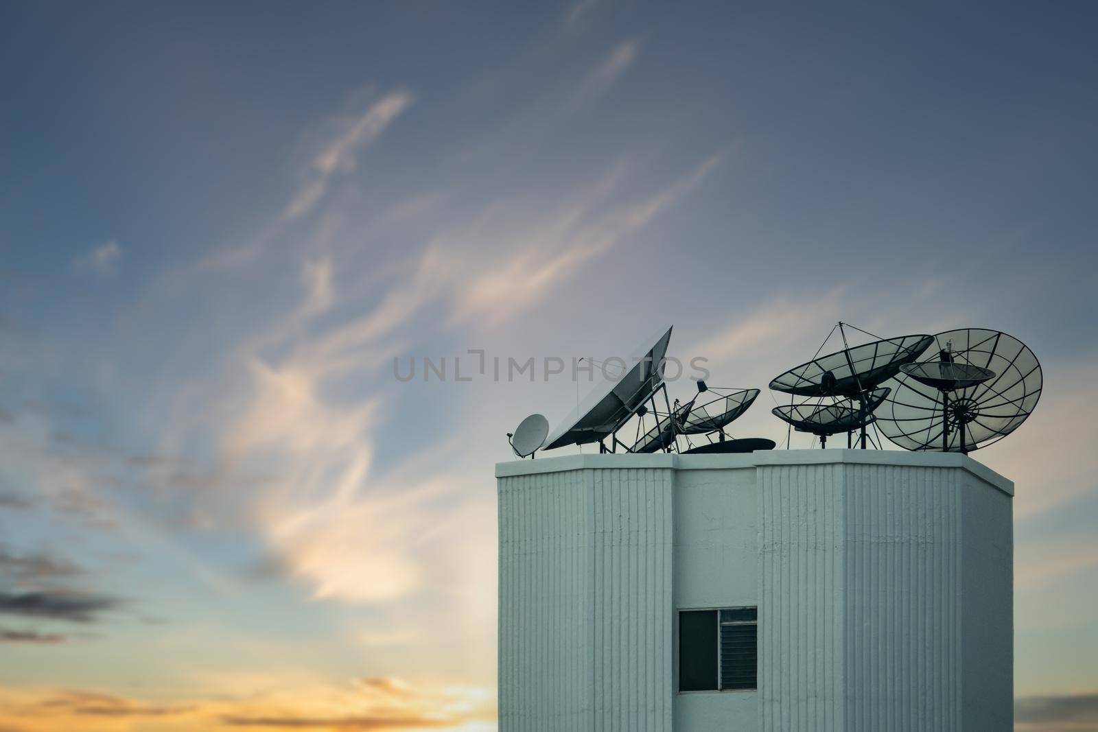 Satellite dish antenna on top of the building with beautiful sky.
