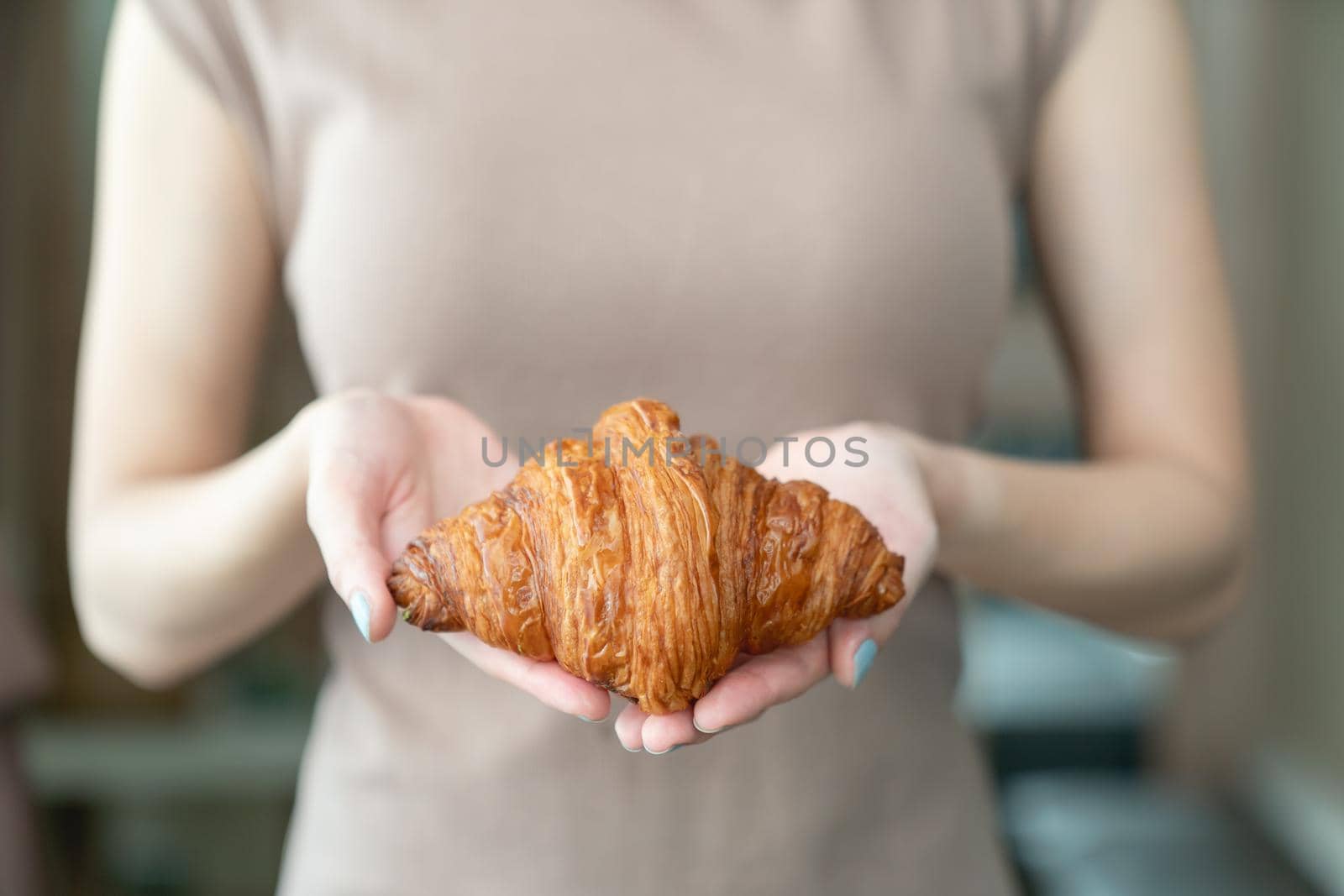 Woman hand serving baked crispy croissants. by sirawit99