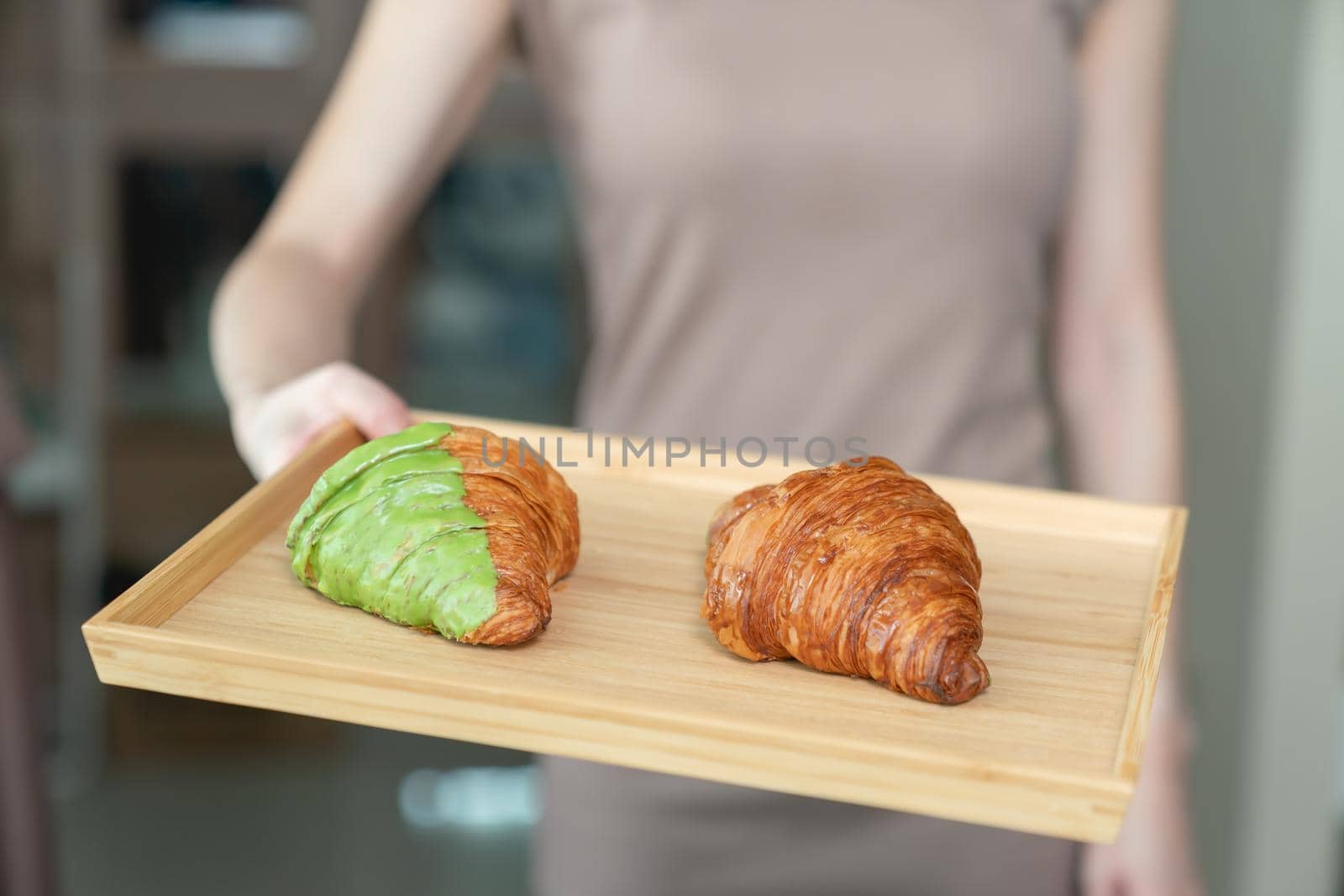 Woman serving baked crispy croissants on wooden tray. by sirawit99