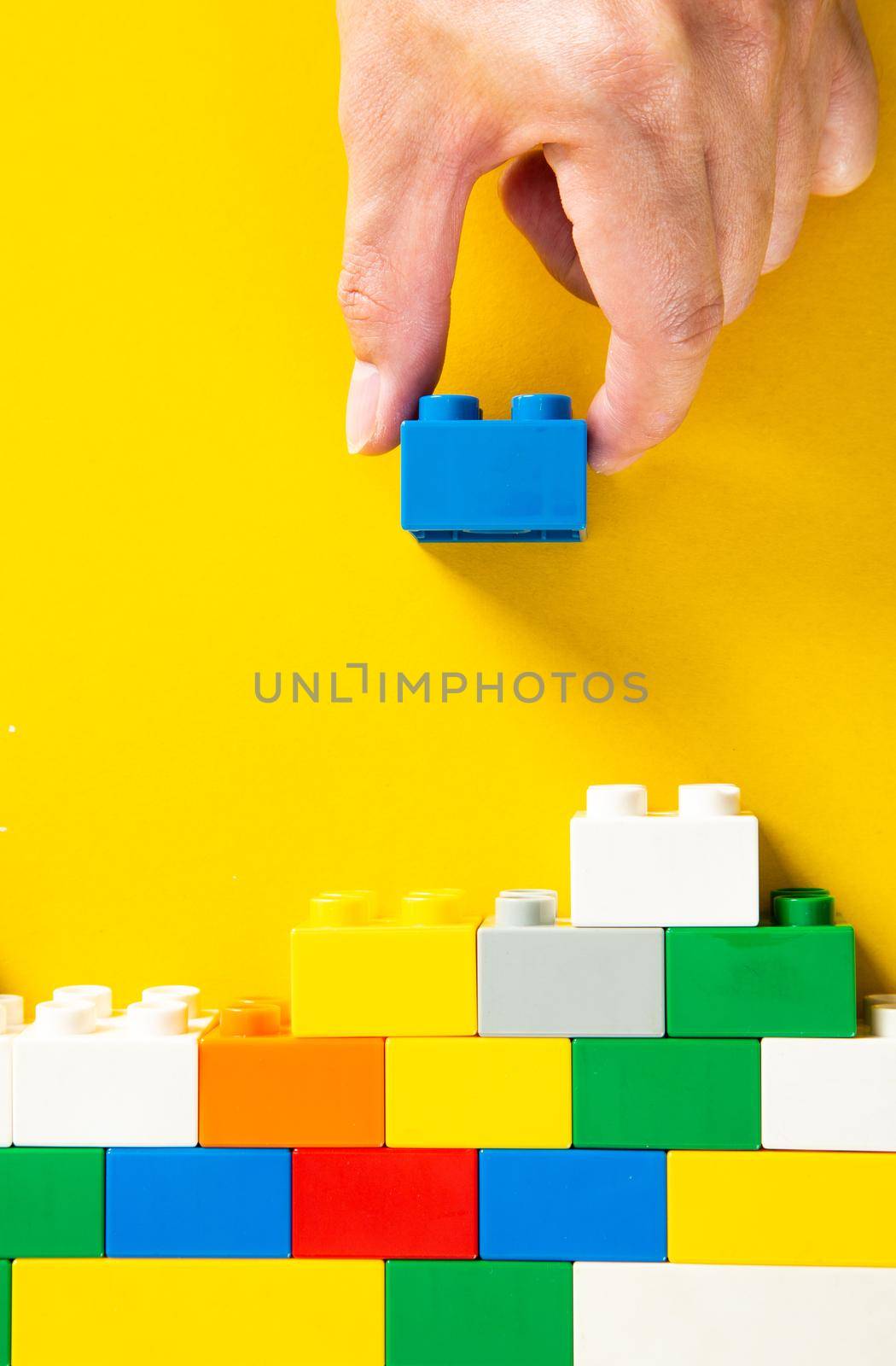 hand stacking up the colorful plastic block