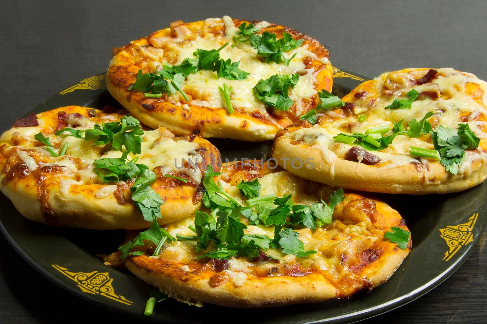 Small pizzas on a black plate