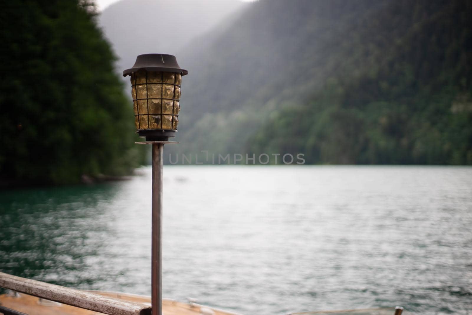 Antique glass and metal lantern on the background of the Ritsa lake. Abkhazia