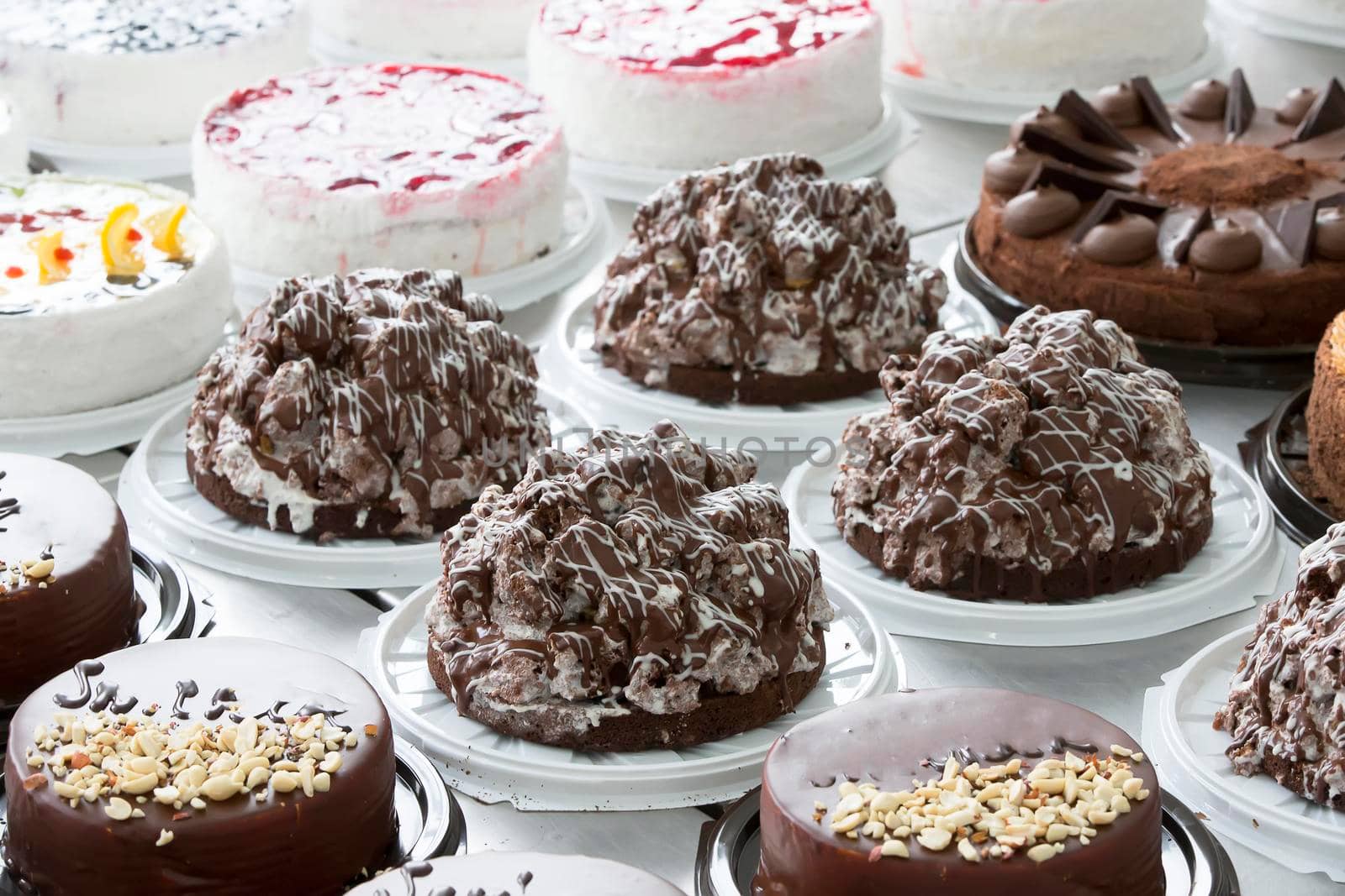 Cake and baking line.Industrial line of cakes. Many beautiful cakes on the table.Multicolored culinary products