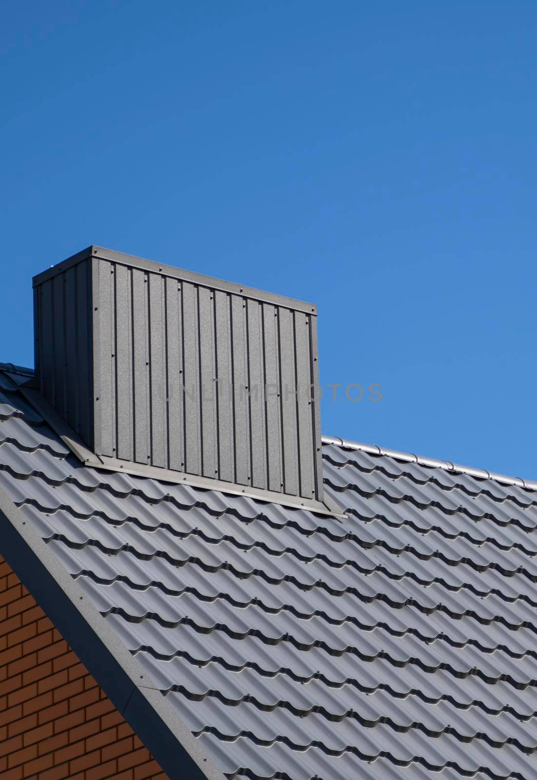 Grey corrugated metal profile roof installed on a modern house. The roof of corrugated sheet. Roofing of metal profile wavy shape. Modern roof made of metal. Metal roofing. by vovsht