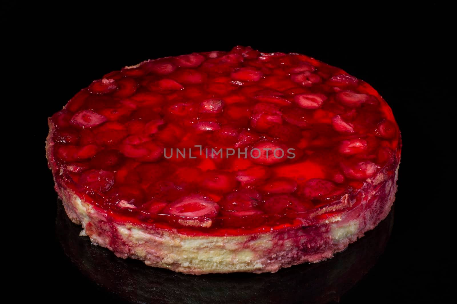 Cake cheesecake with strawberries in jelly on black background