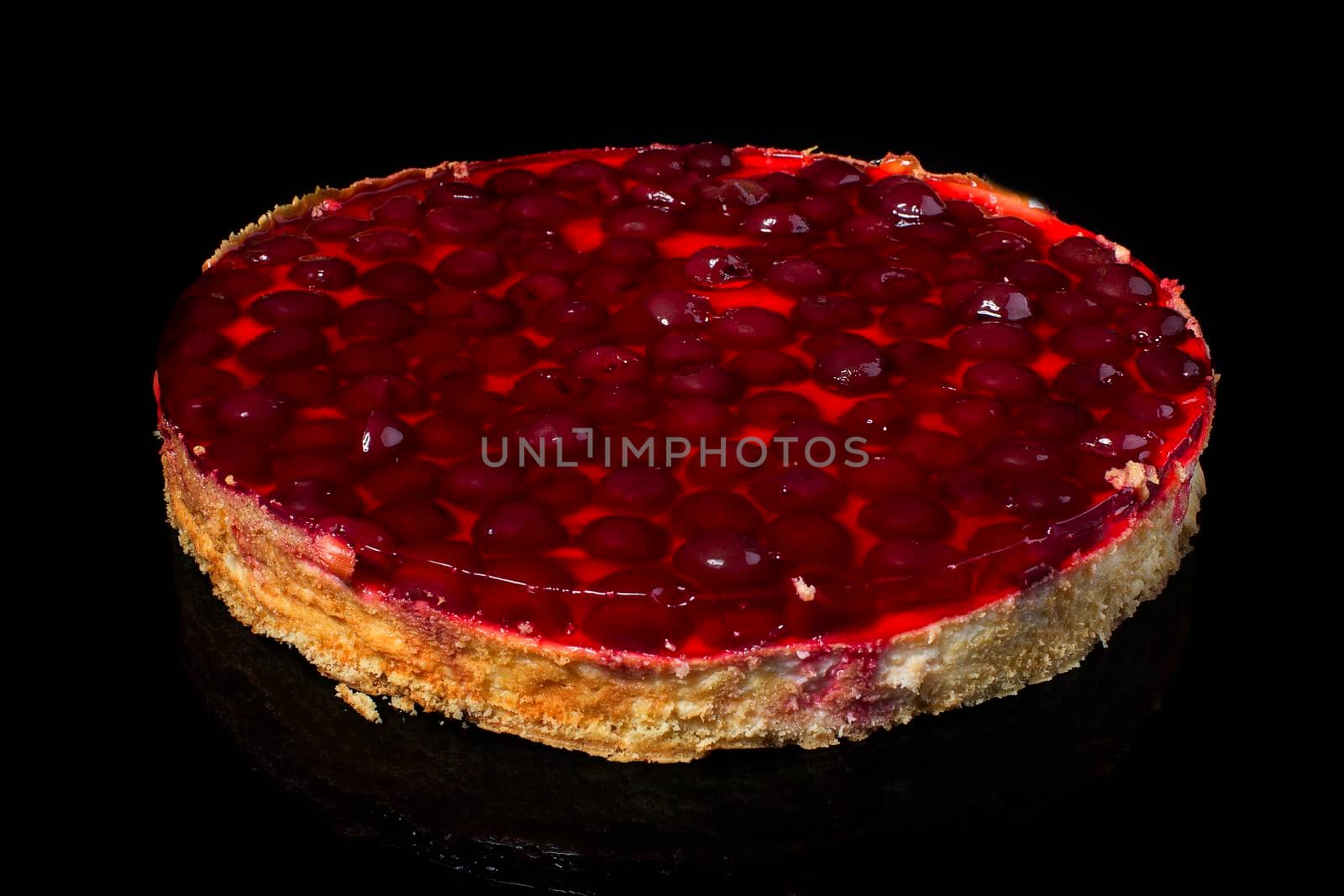 Cake cheesecake with cherry in jelly on black background