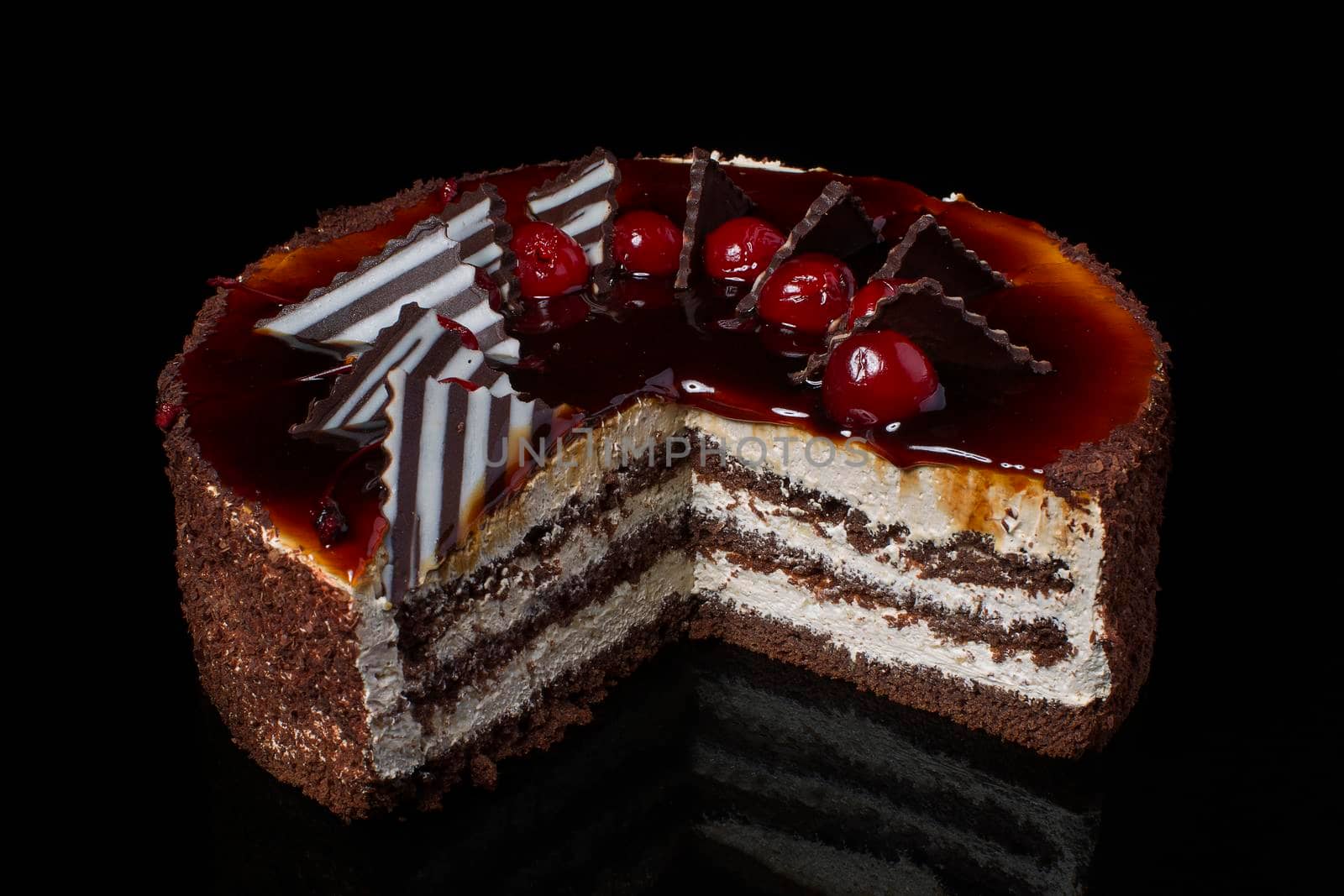 A piece of chocolate cake with white cream on a black background