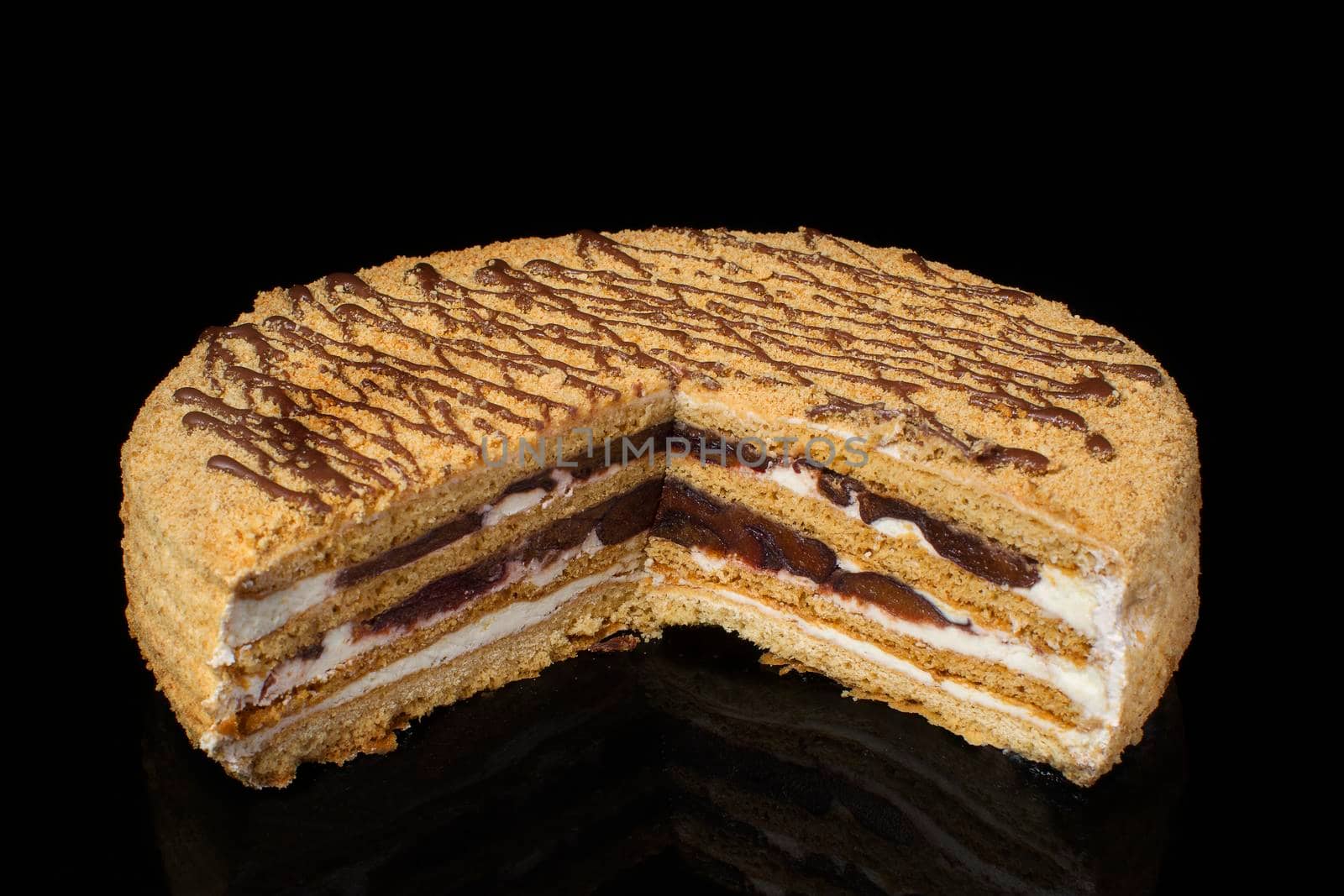 A piece of shortcake cake covered with peanuts on a dark background