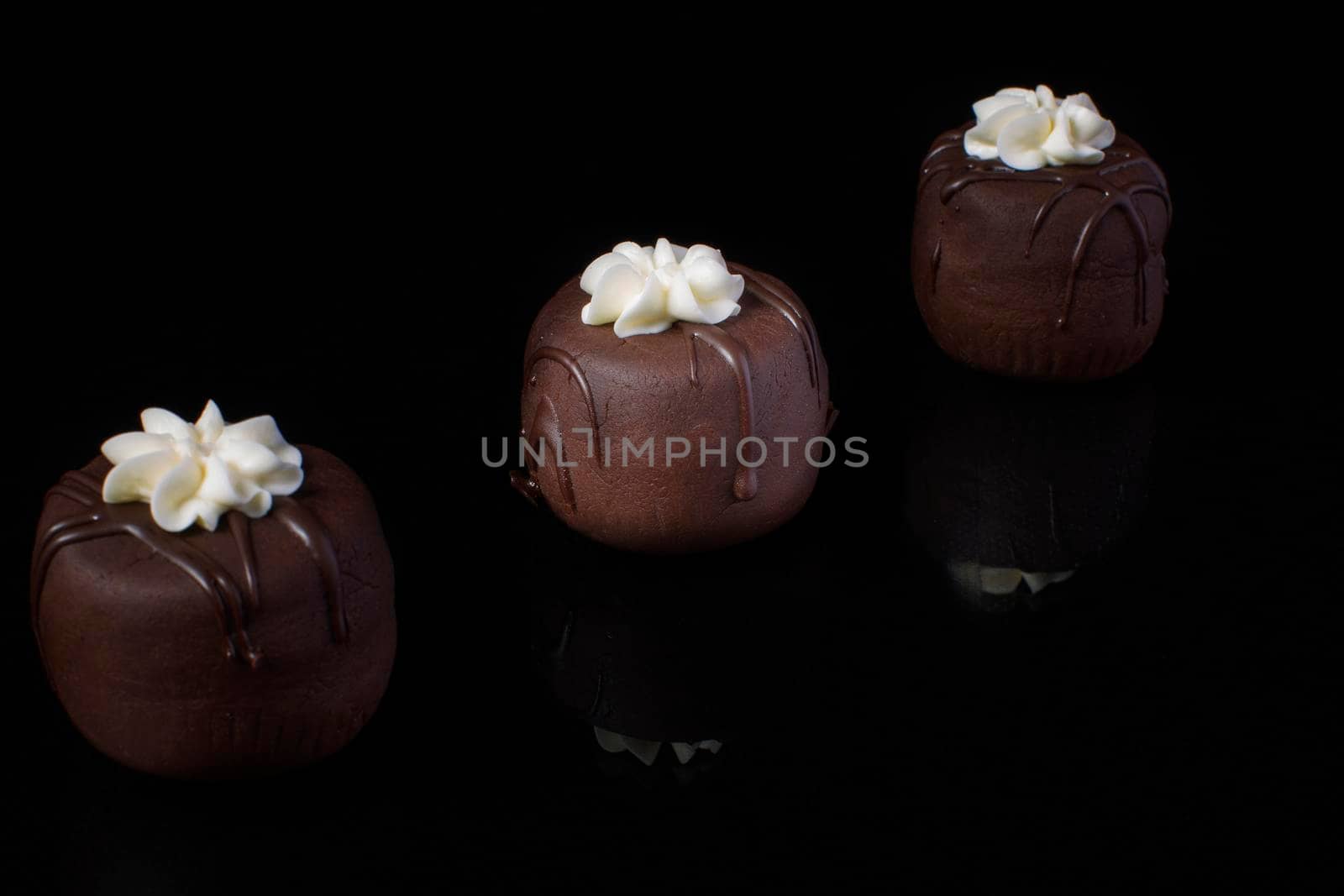Small chocolate cakes on a black background.Brownie.Russian Potato Cake