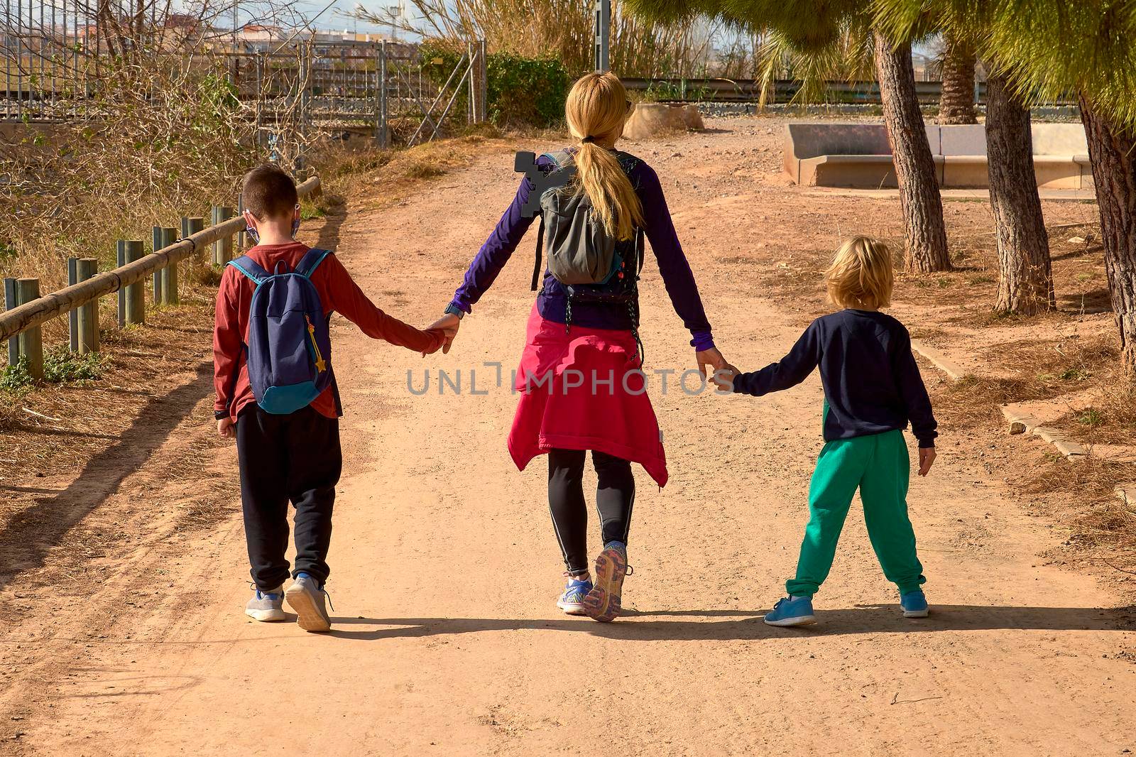 Blonde girl holding hands with two children. sport clothes, caucasian, blond, blonde, blonde, siblings, mother sport happy lifestyle