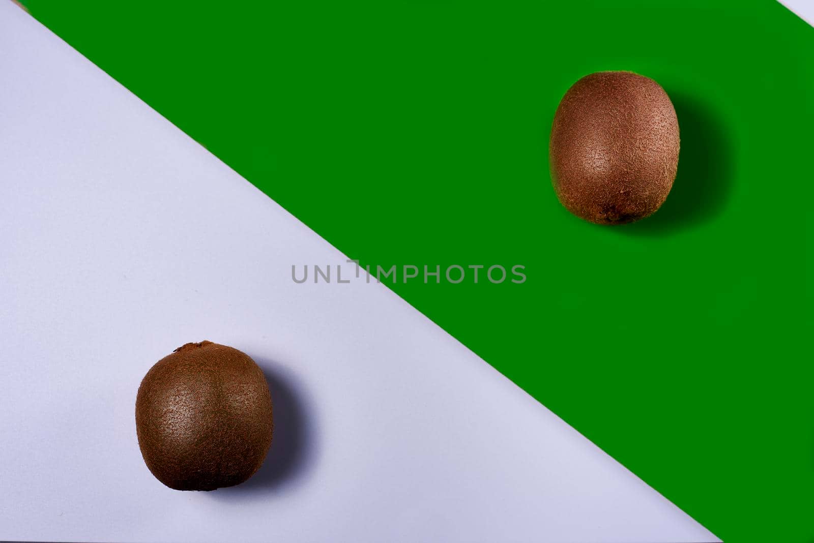 Two kiwis on white and green ground. Smooth background, symmetrical, straight lines, luminous