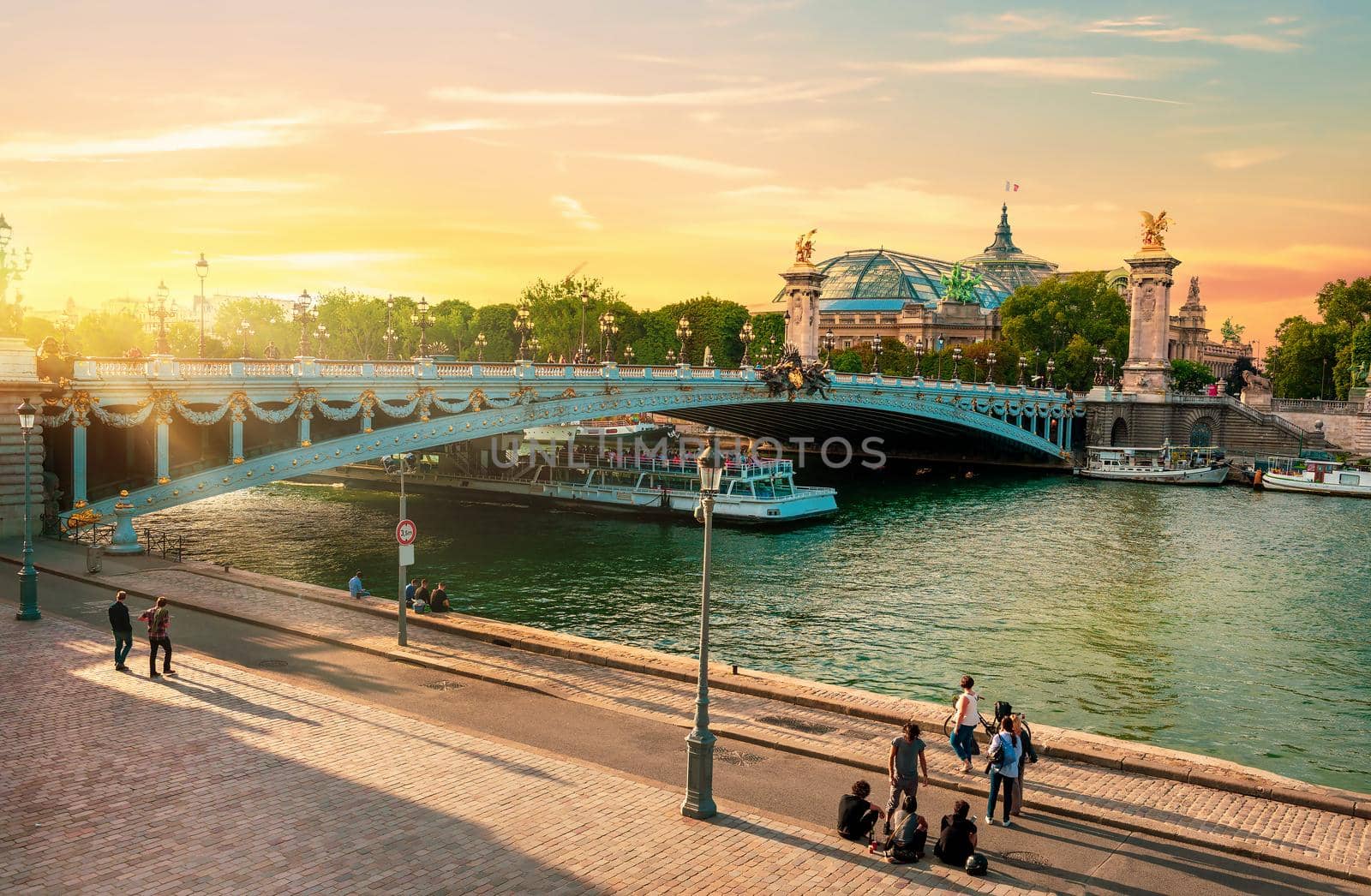 Embankment near bridge of Alexandre III in Paris at sunset