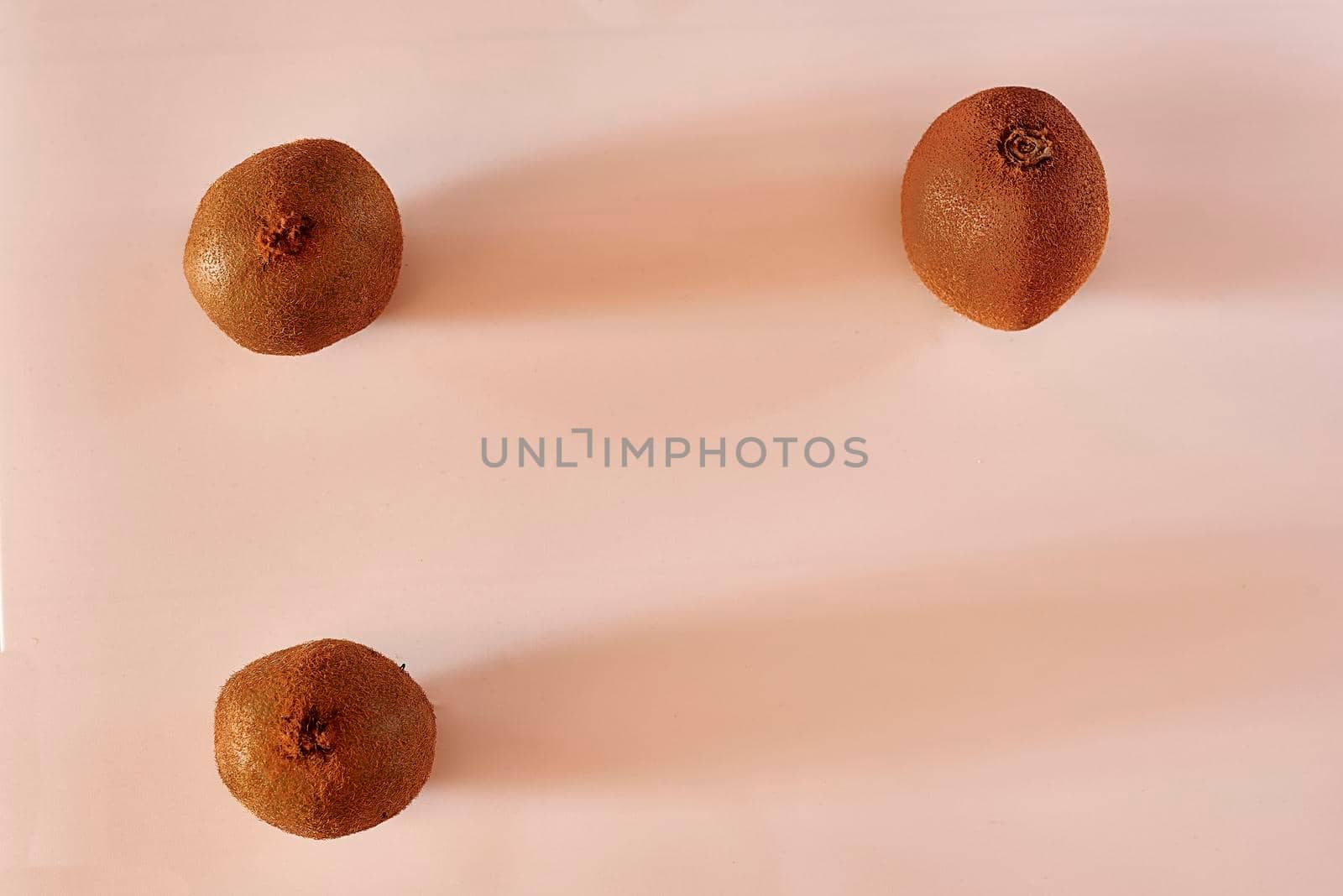 Three kiwis on a white background, symmetry, clean background, shadows