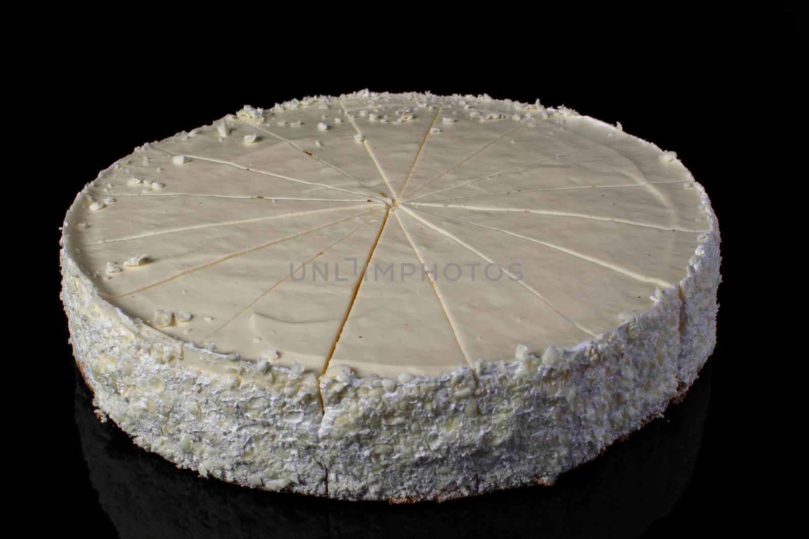 Cake cheesecake sliced in portions on a black background
