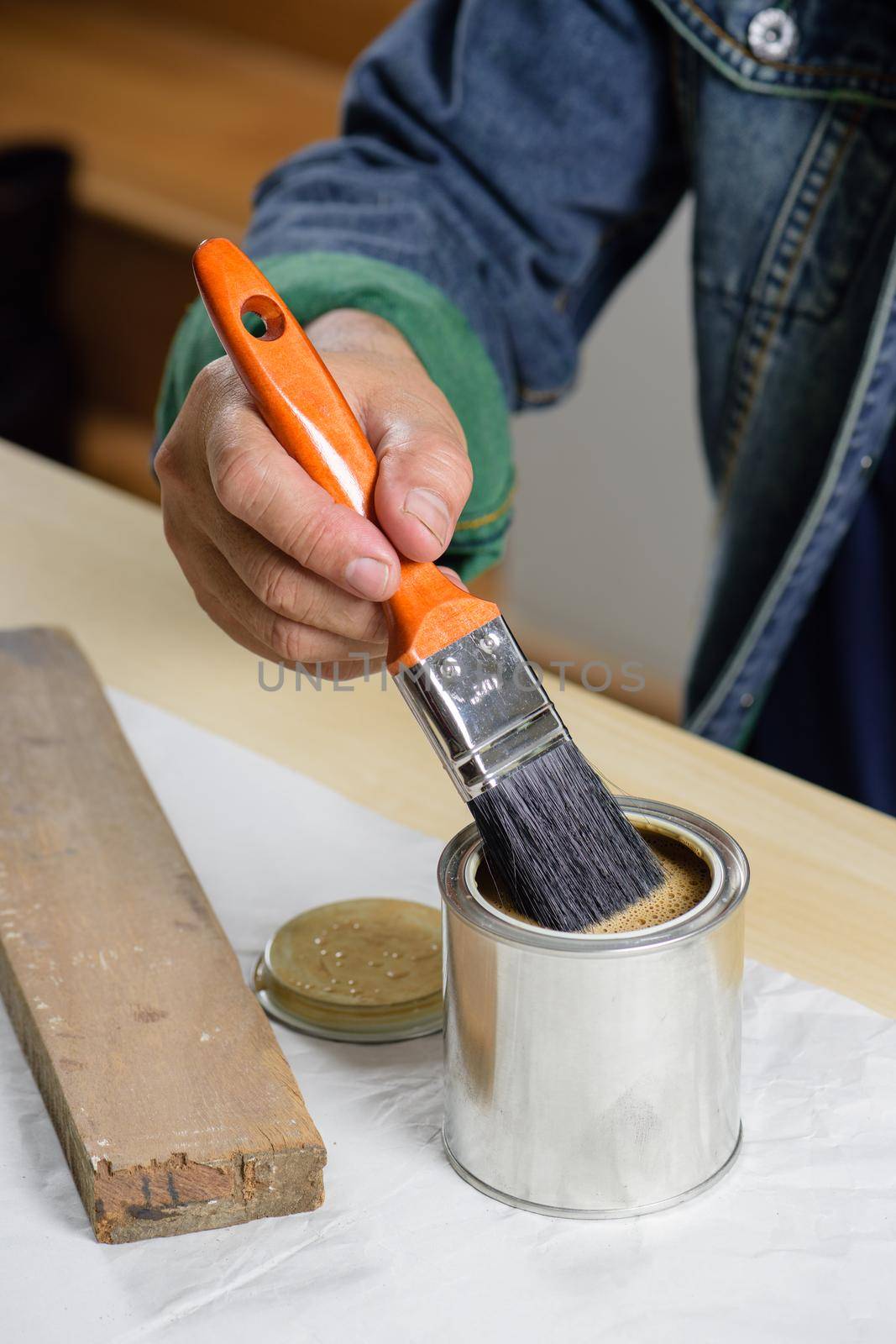 closeup the man hand using paintbrush to painting the wood plank