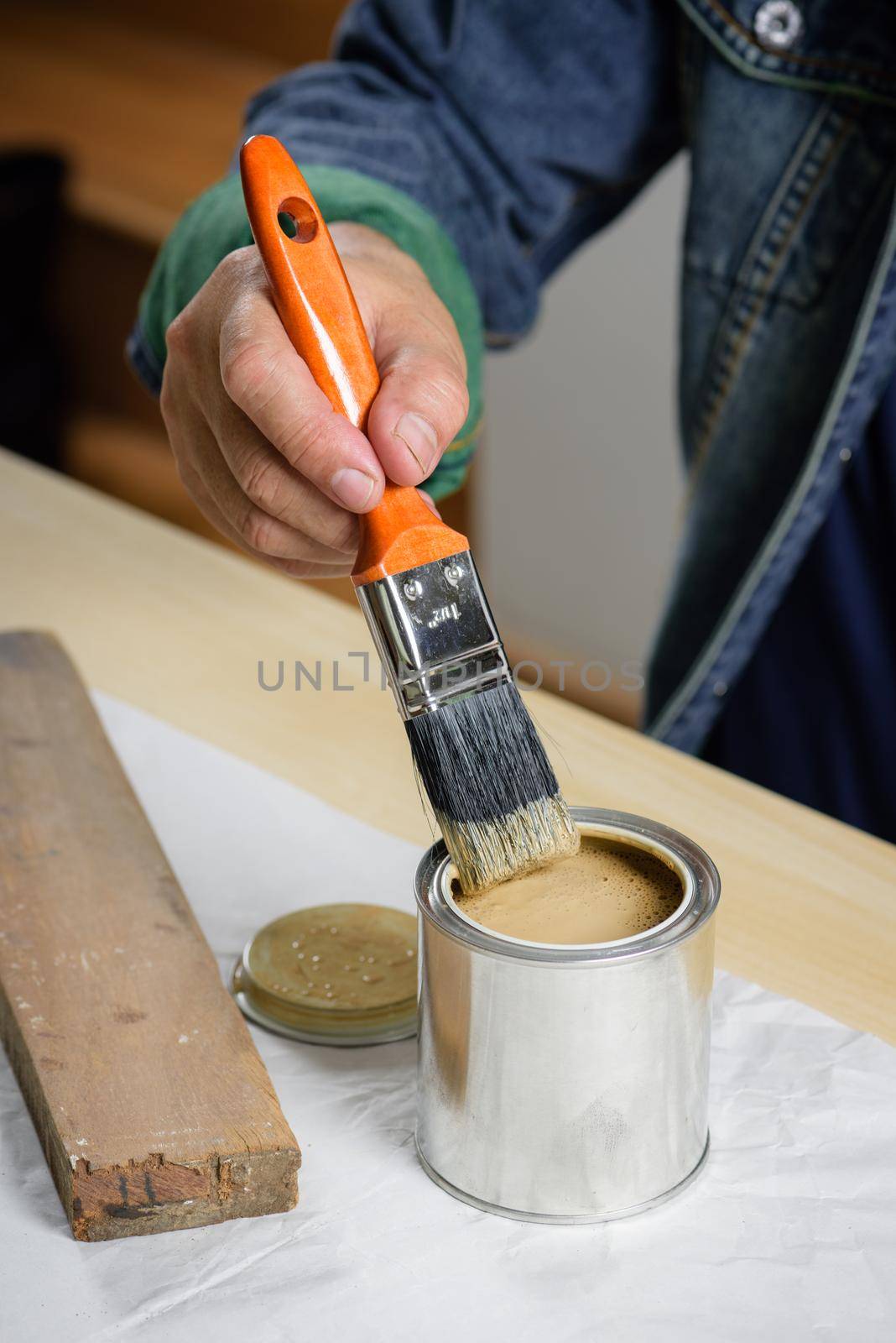 closeup the man hand using paintbrush to painting the wood plank