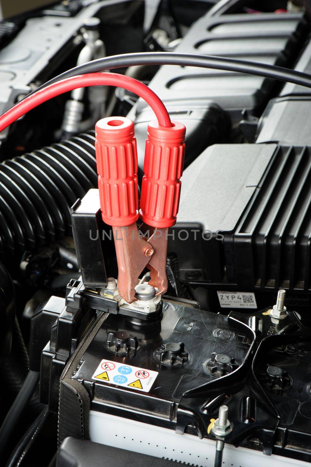 car battery with jumper cable in engine room, car repairing concept