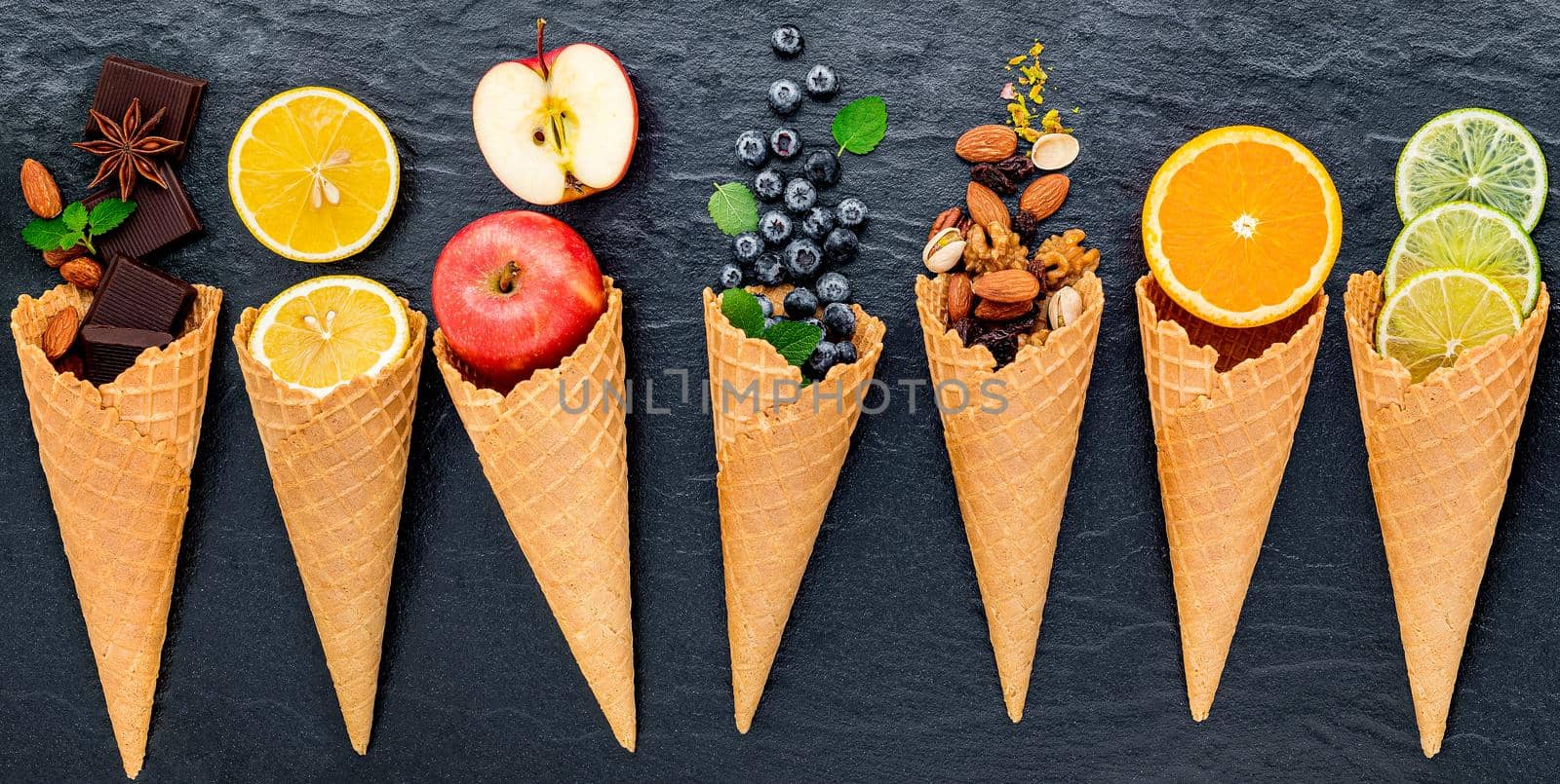 Various of ingredient for ice cream flavor in cones  set up on dark stone background . 