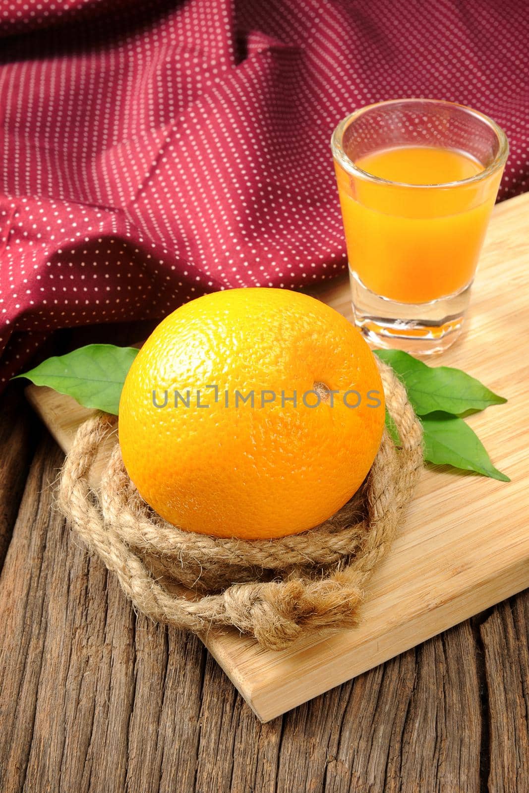 Ripe orange and cup of orange juice on wooden table