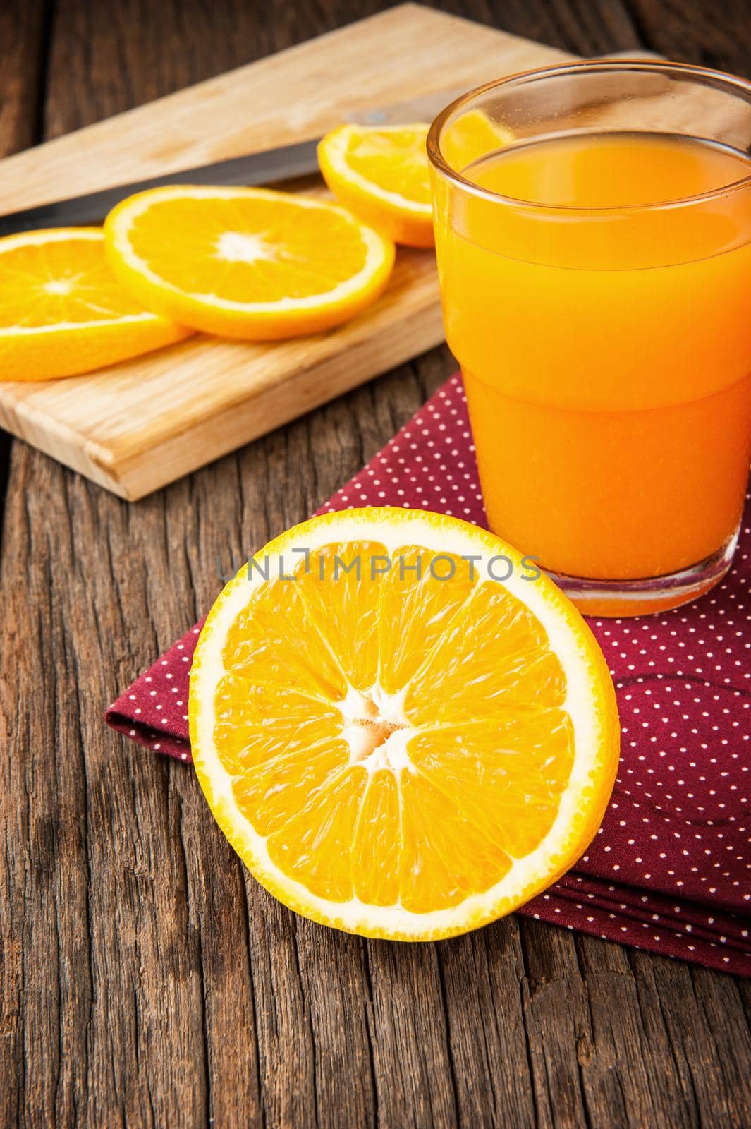Ripe orange and orange juice on wooden table