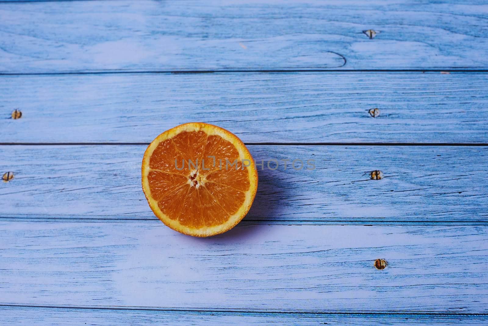 Half an orange on wooden floor by raul_ruiz