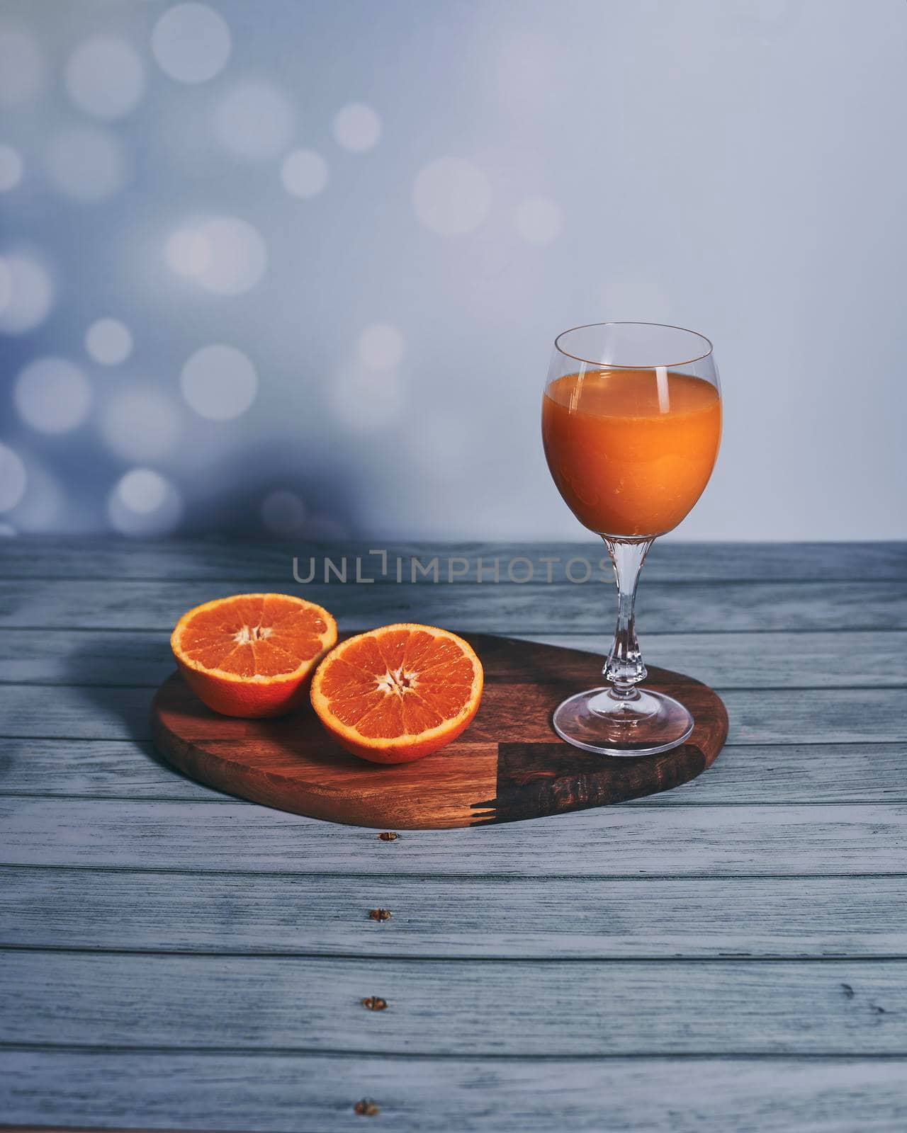 Glass of orange juice on wooden table, half orange, wooden floor, bright sound
