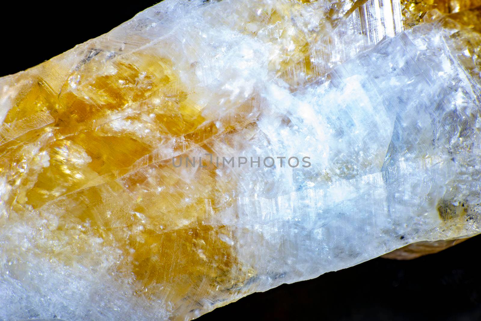 macro shooting of natural rock specimen. Raw crystal of Citrine yellow quartz gemstone from Brazil. Shimmering gold background. High quality photo